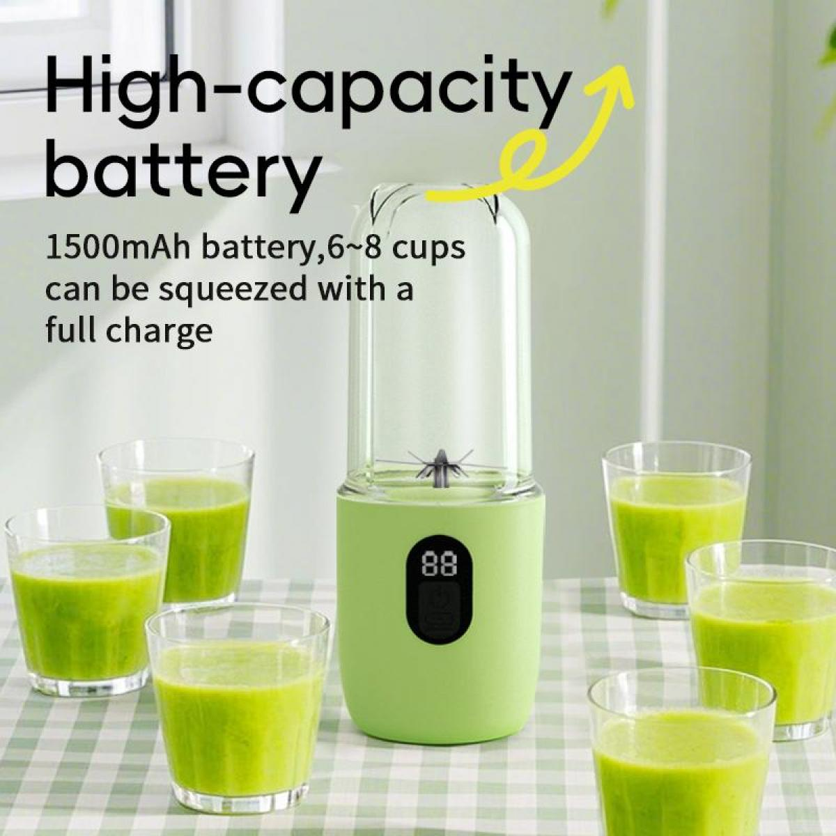 Ein hellgrüner Mixer mit Gläsern voller grünen Saft auf kariertem Tisch.