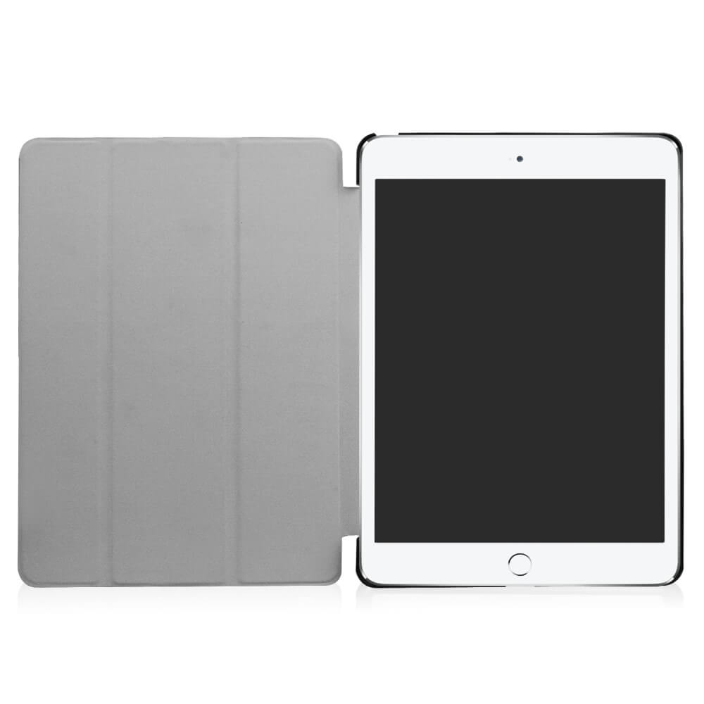 Une tablette grise avec une couverture ouverte repose sur une surface blanche.