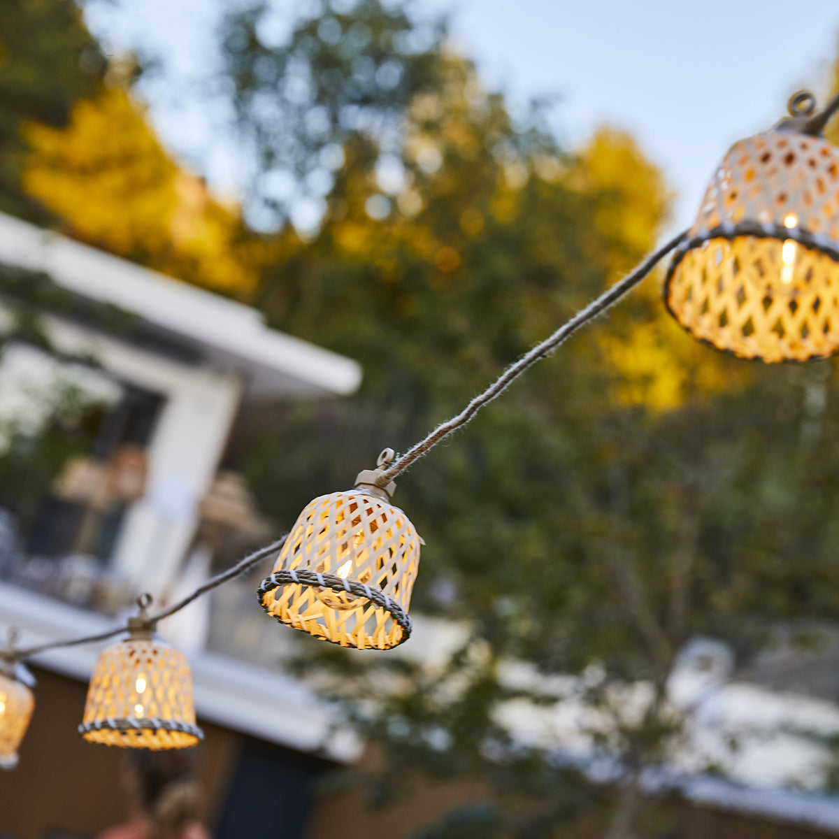 Lichterkette mit Laternen aus geflochtenem Material, leuchtend.