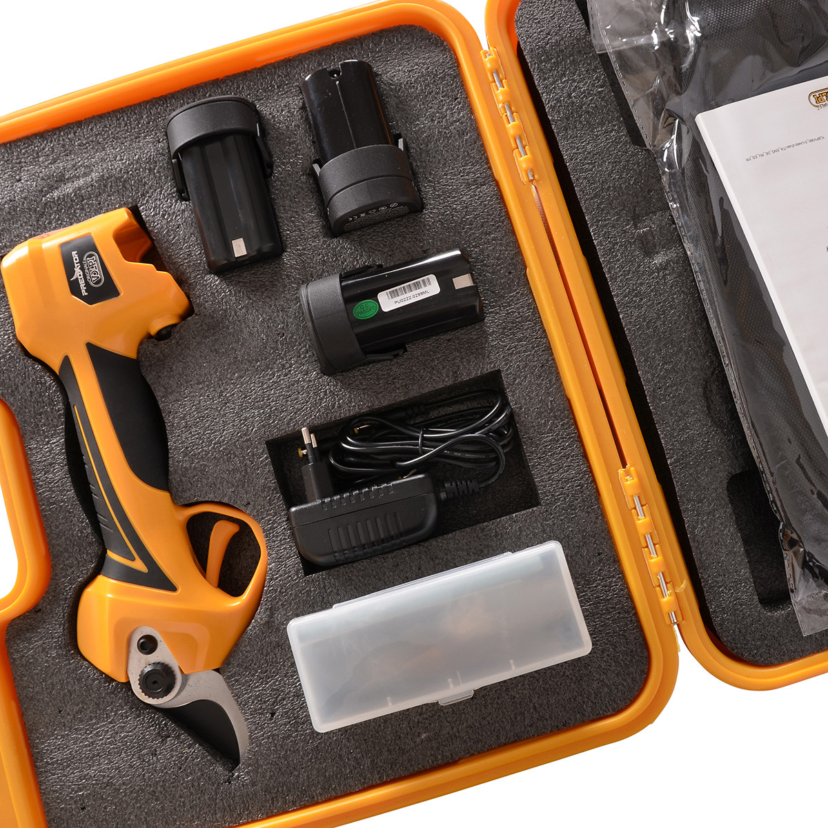 Żółty zestaw sekatora z narzędziem, bateriami i ładowarką w pomarańczowej walizce.