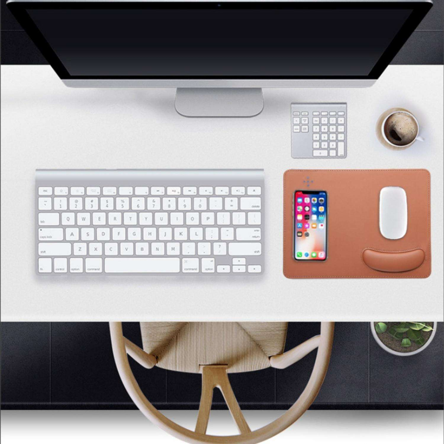 Ein Schreibtisch mit Monitor, Tastatur, Maus, Handy, Kaffee und Stuhl.