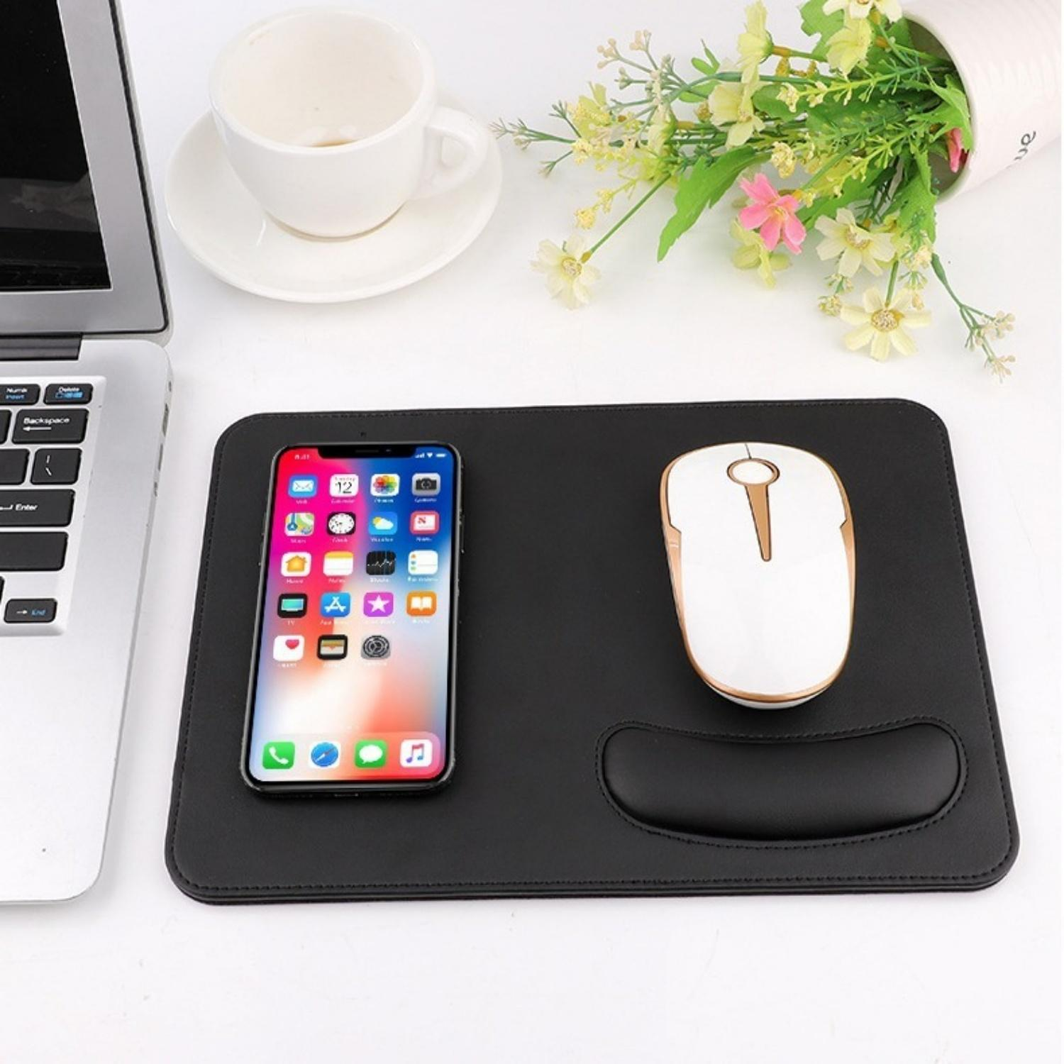 Ein Smartphone und eine Maus liegen auf einem schwarzen Mauspad neben einem Laptop.