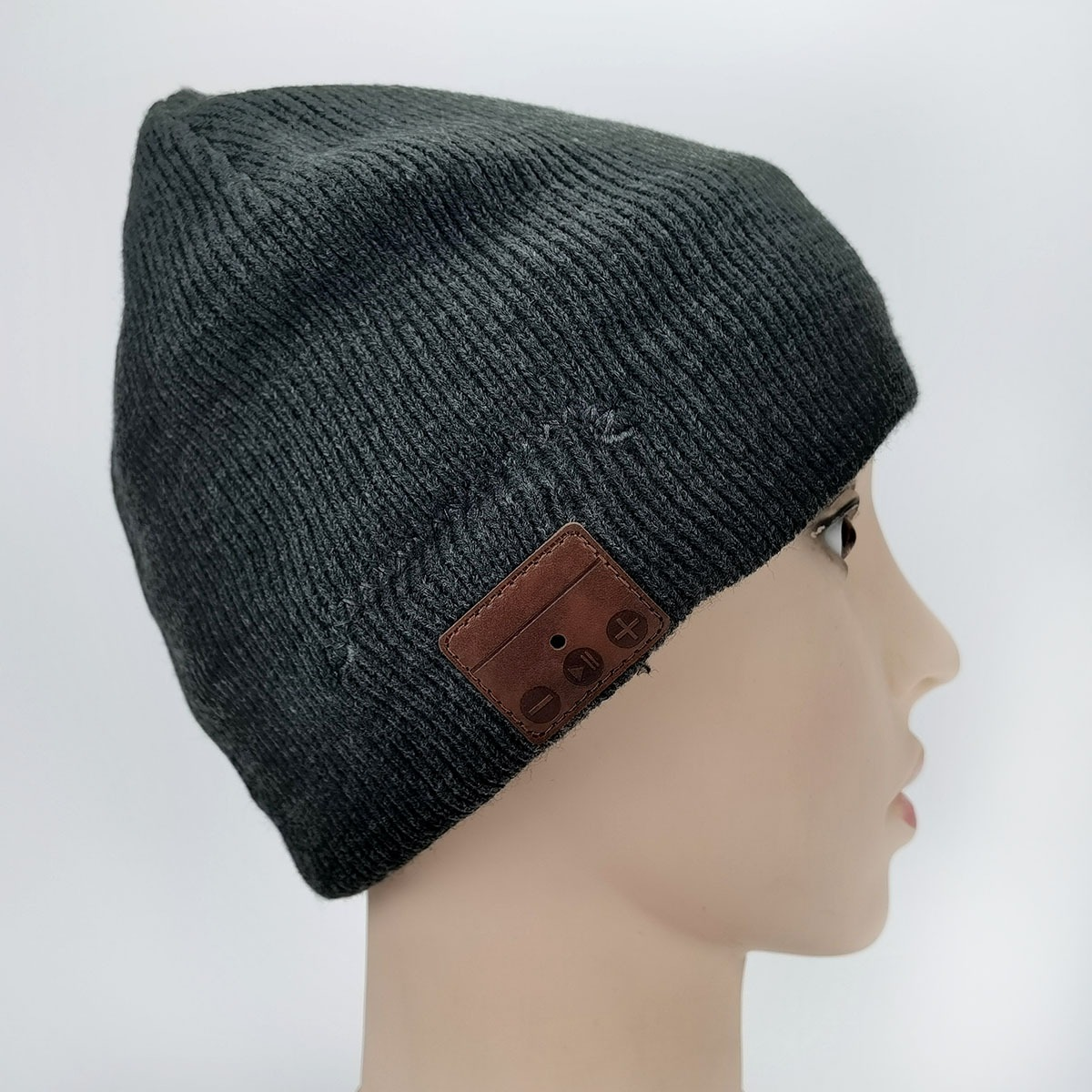 Donkergrijs gebreide muts met bruin leren patch en knoppen.