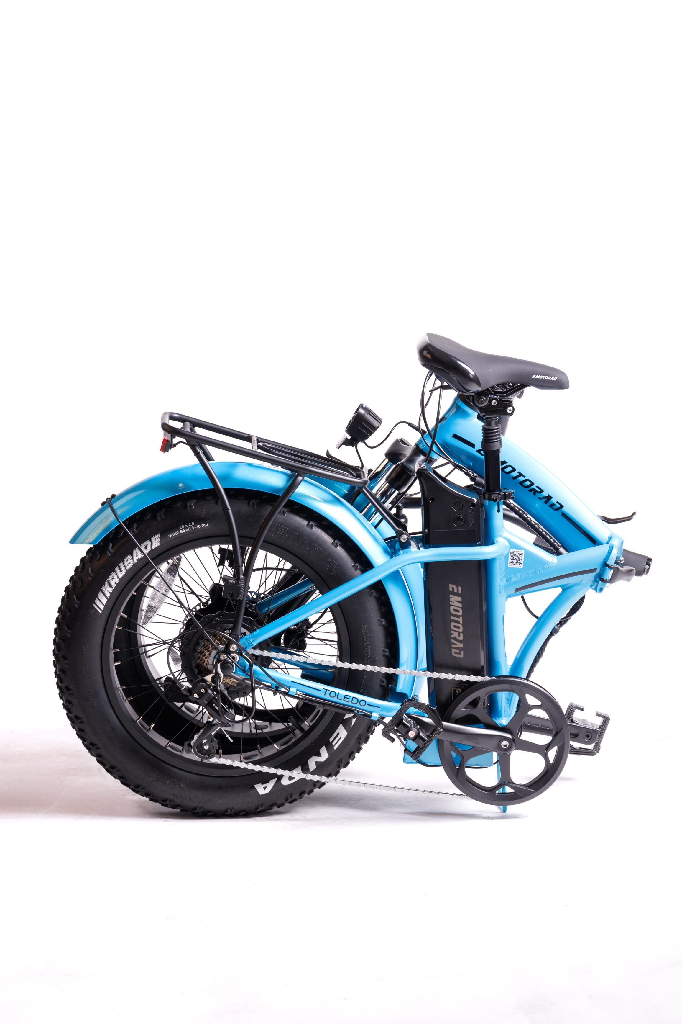 Una bicicleta eléctrica azul con neumáticos anchos, plegada, en estudio.
