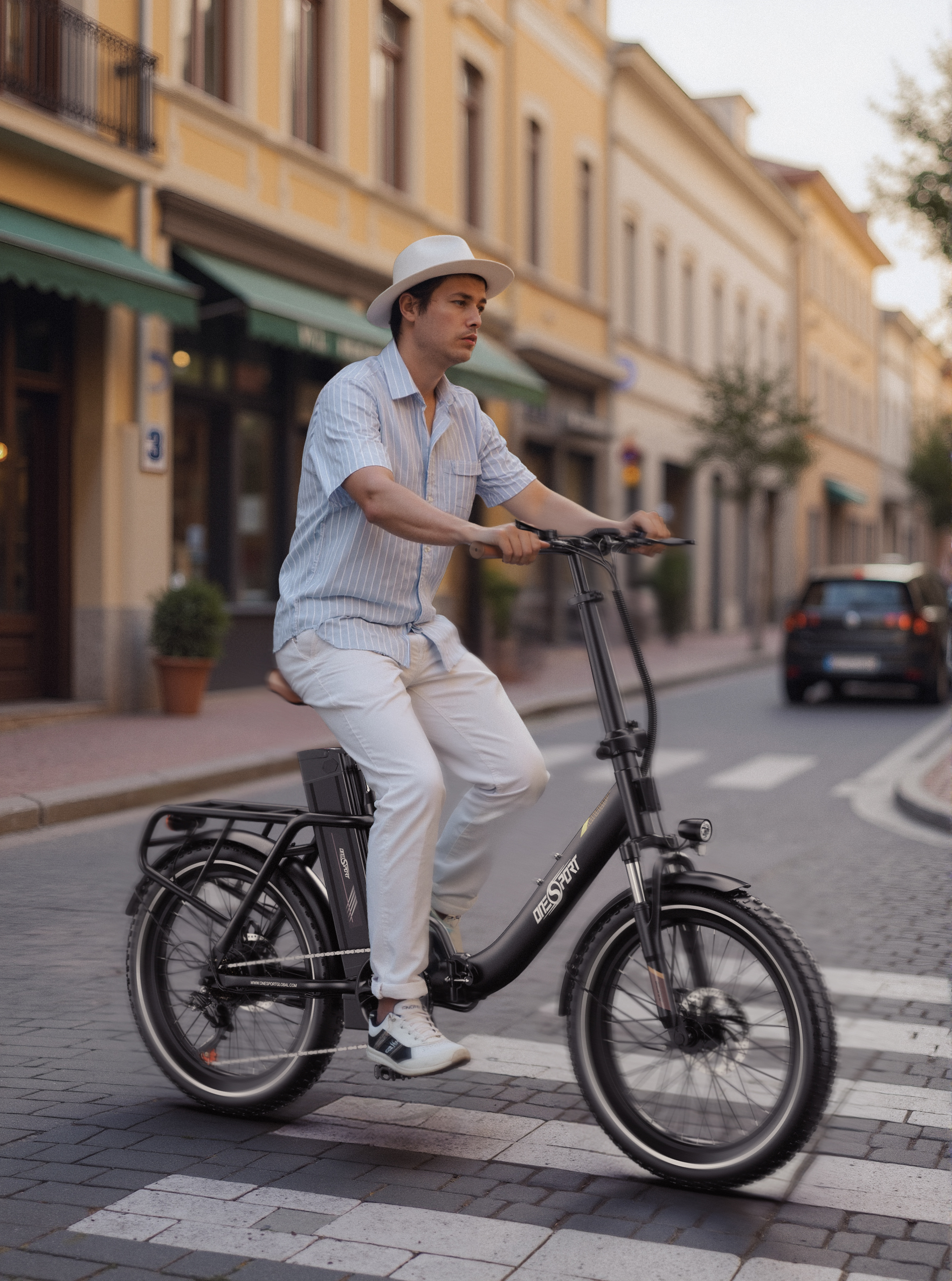 Ein Mann mit weißem Hut fährt ein schwarzes E-Bike über eine Straße mit Zebrastreifen.