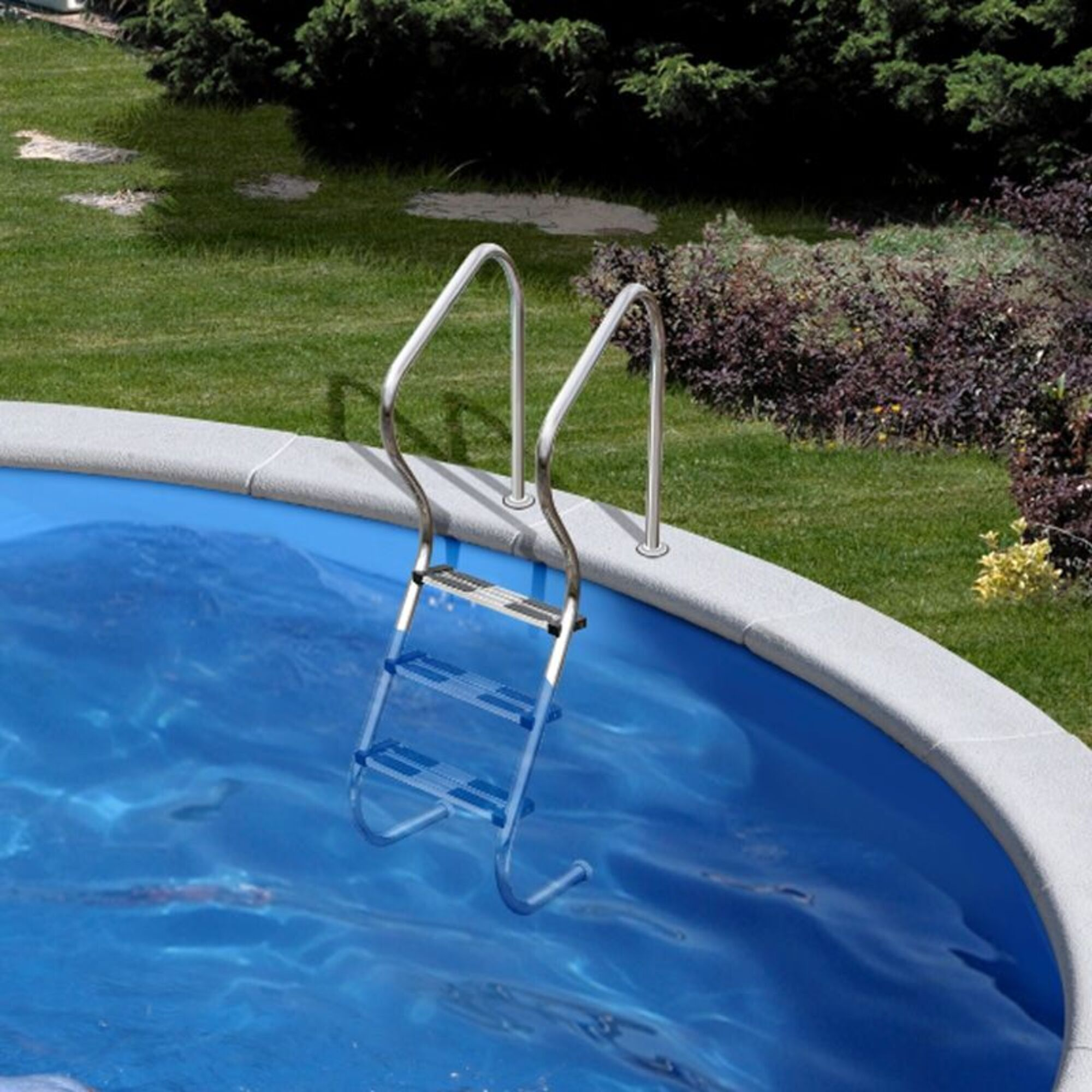 Una escalera sale de una piscina azul hacia un jardín verde.
