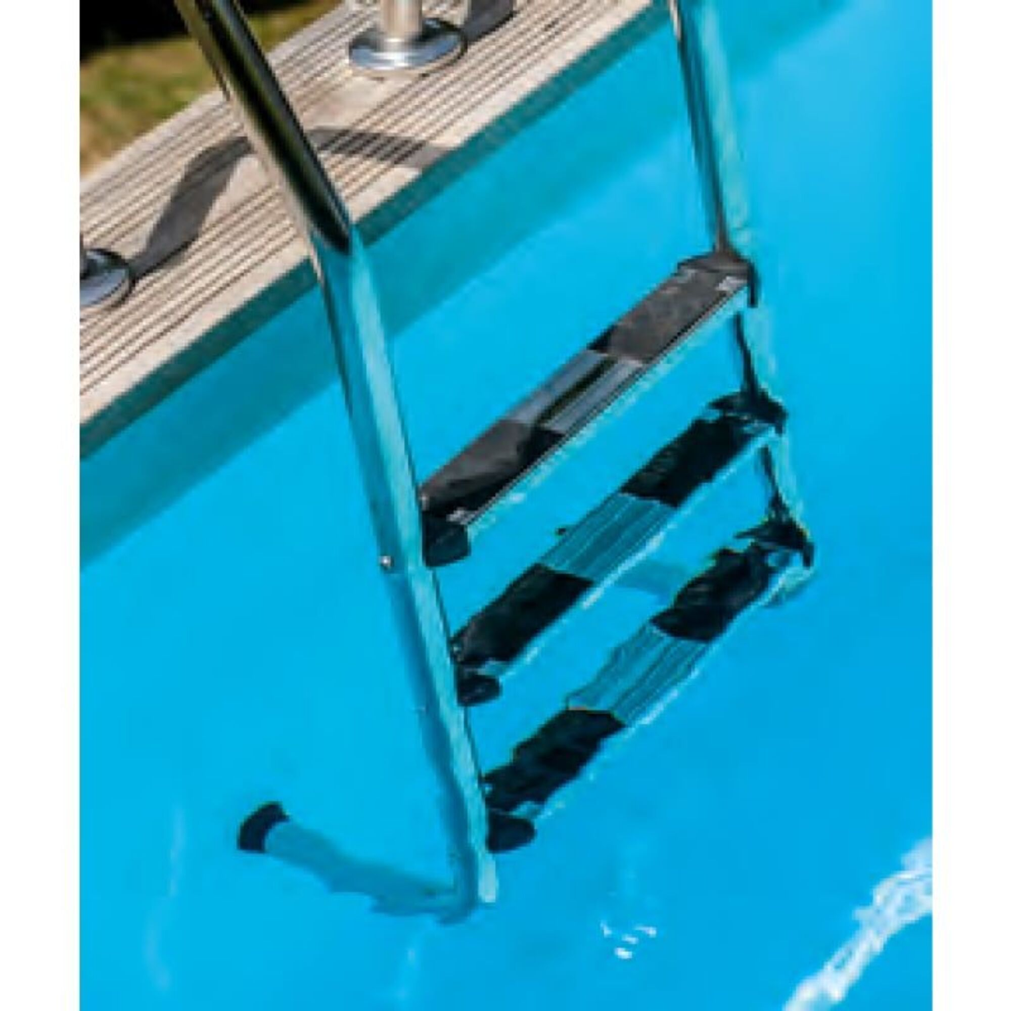 Escalera de acero inoxidable con peldaños negros se extiende hacia agua de piscina azul clara.