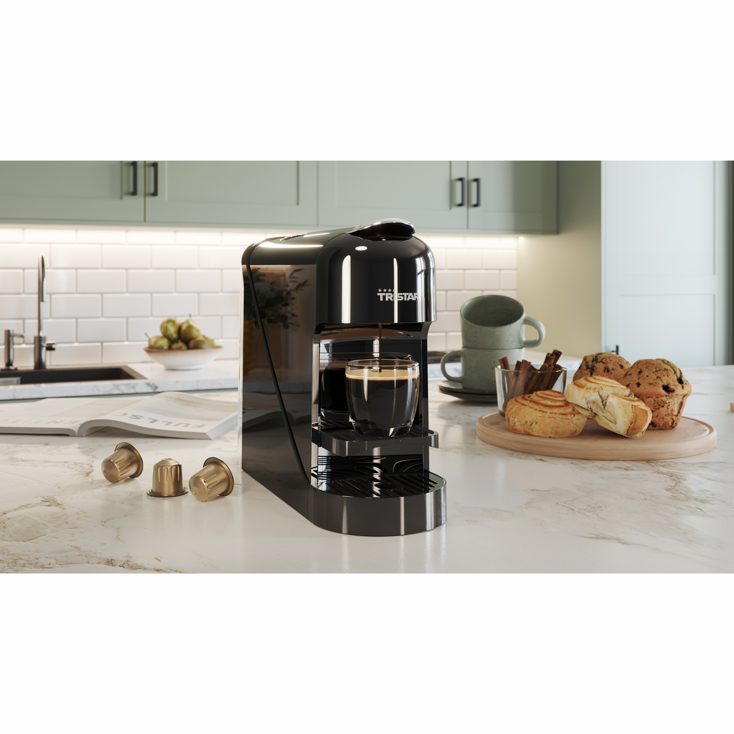 Ekspres do kawy z filiżanką kawy, kapsułkami i ciastkami na blacie kuchennym.