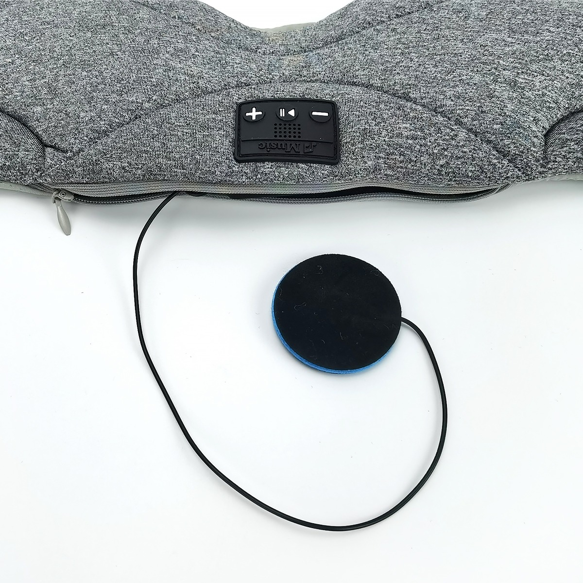 Masque de sommeil gris avec boutons intégrés et écouteur détaché sur fond blanc.