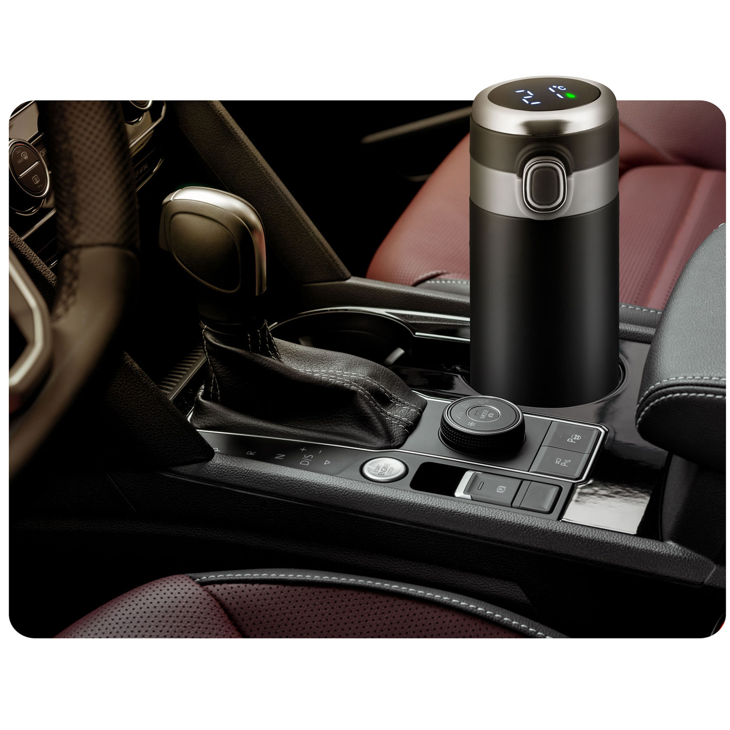 Czarny kubek termiczny z cyfrowym wyświetlaczem stoi na konsoli środkowej samochodu.