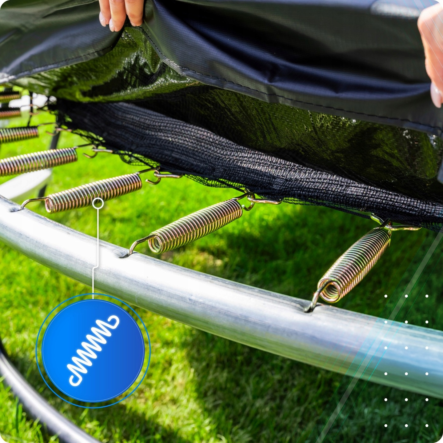 Zbliżenie sprężyn trampoliny przymocowanych do metalowej ramy na trawie.