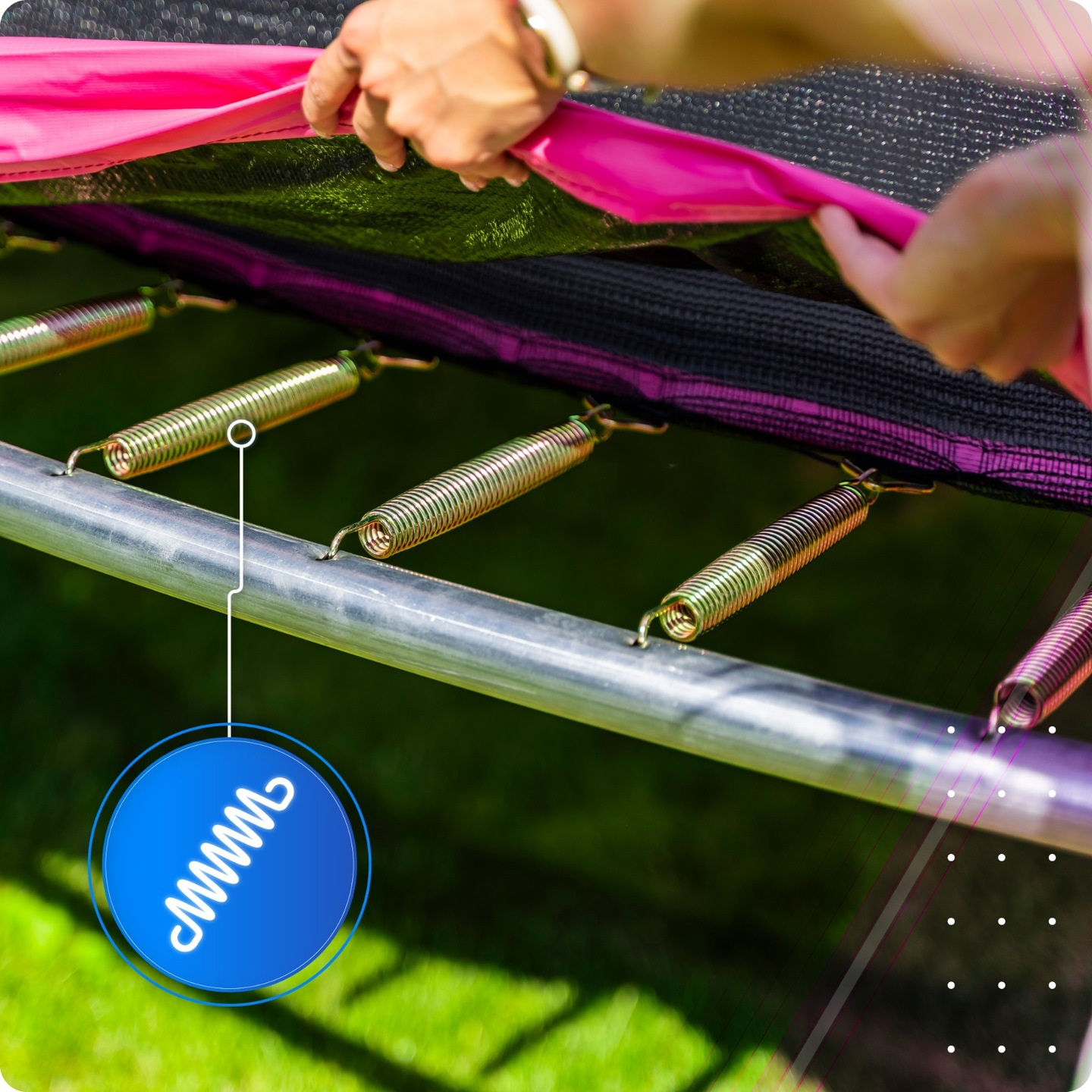 Osoba mocuje różową matę do ramy trampoliny. Widoczne metalowe sprężyny.