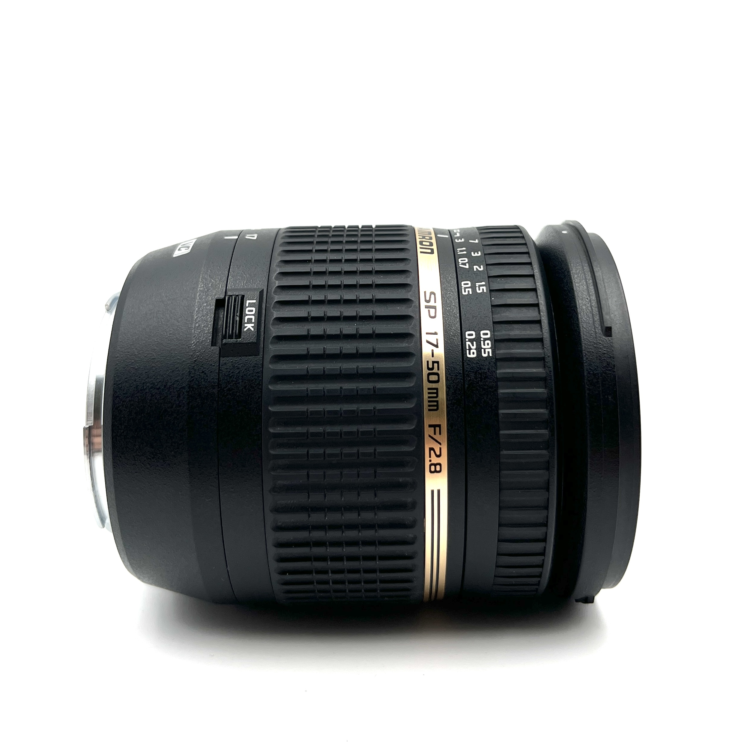 Ein schwarzes Tamron SP 17-50mm F/2.8 Objektiv liegt auf weißem Hintergrund.