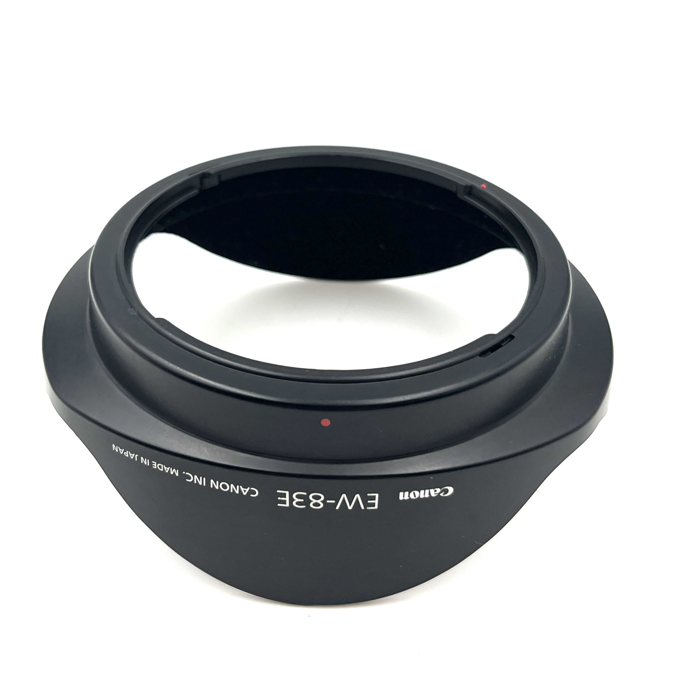 Czarny, plastikowy tulipan obiektywu Canon EW-83E na białym tle.