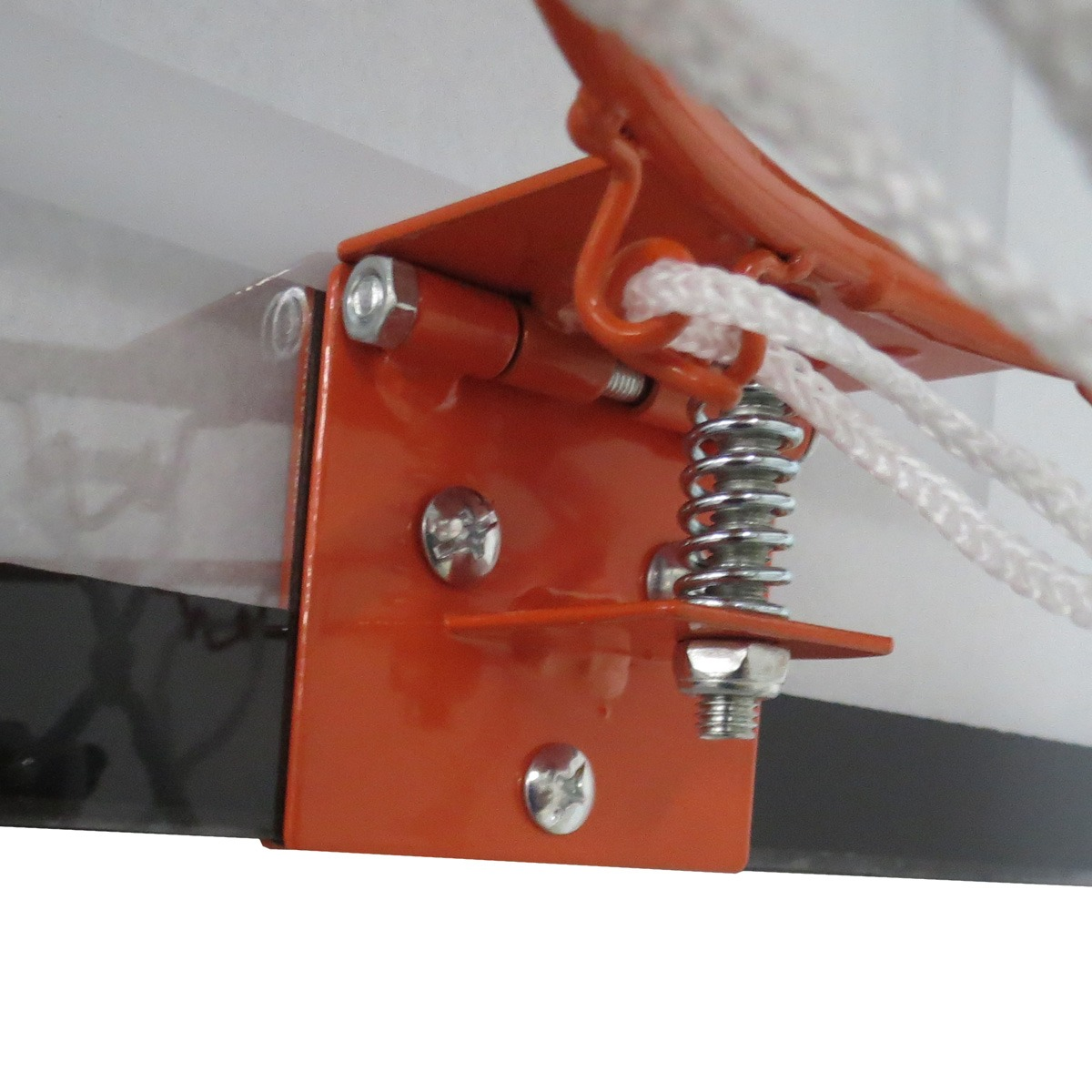 Close-up of an orange basketball hoop bracket with spring and rope detail.