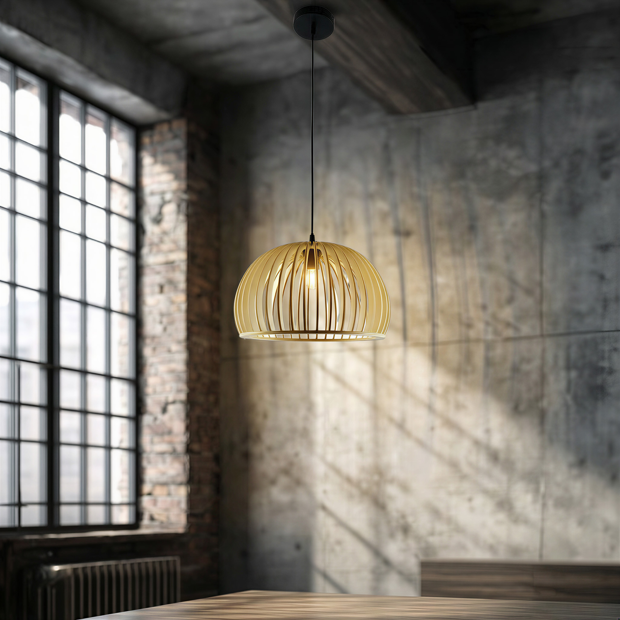 Eine goldene Pendelleuchte hängt über einem Holztisch in einem Raum mit Betonwänden.