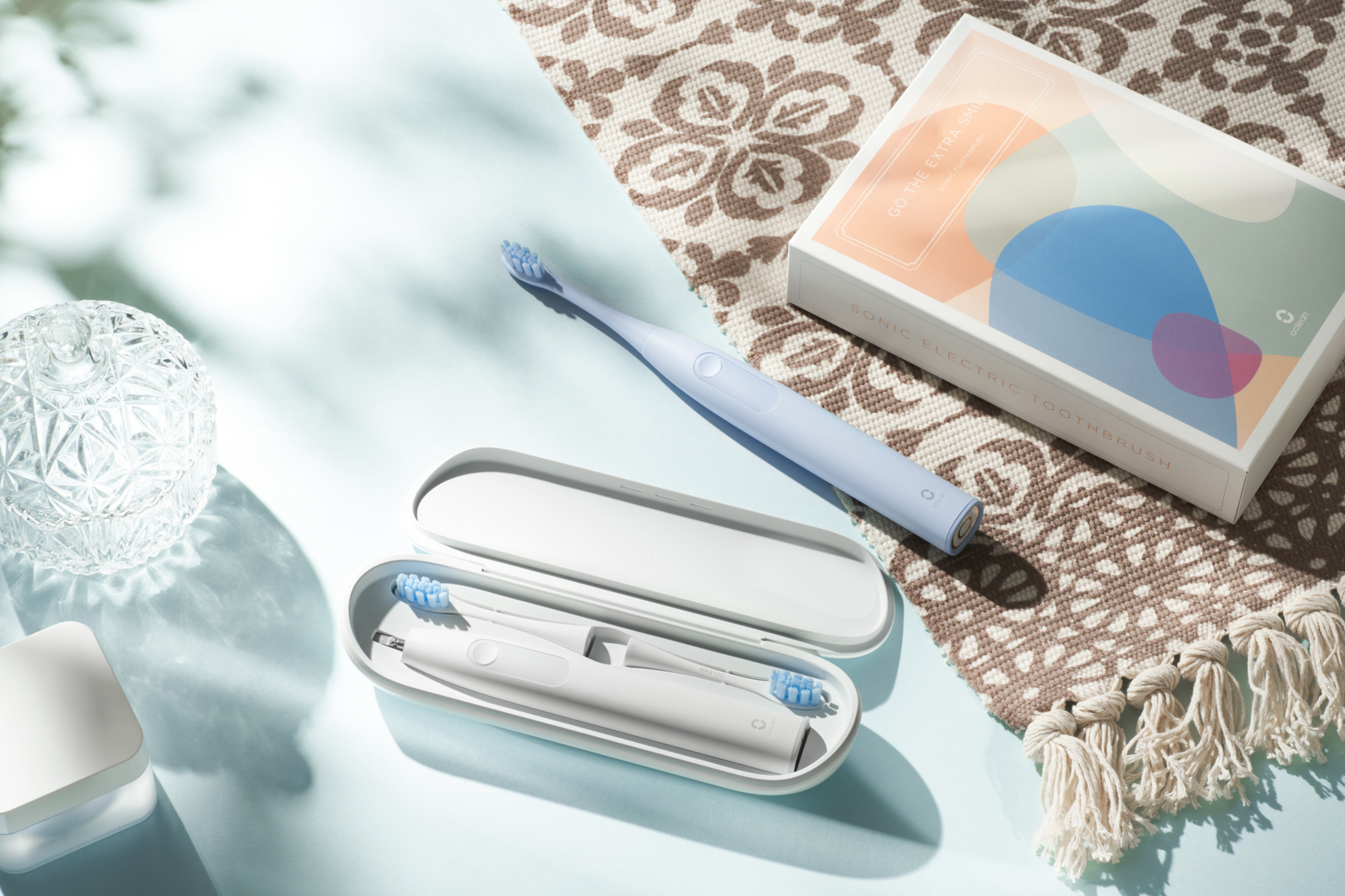 Ein blaues und ein weißes Schallzahnbürsten-Set mit Reiseetui.