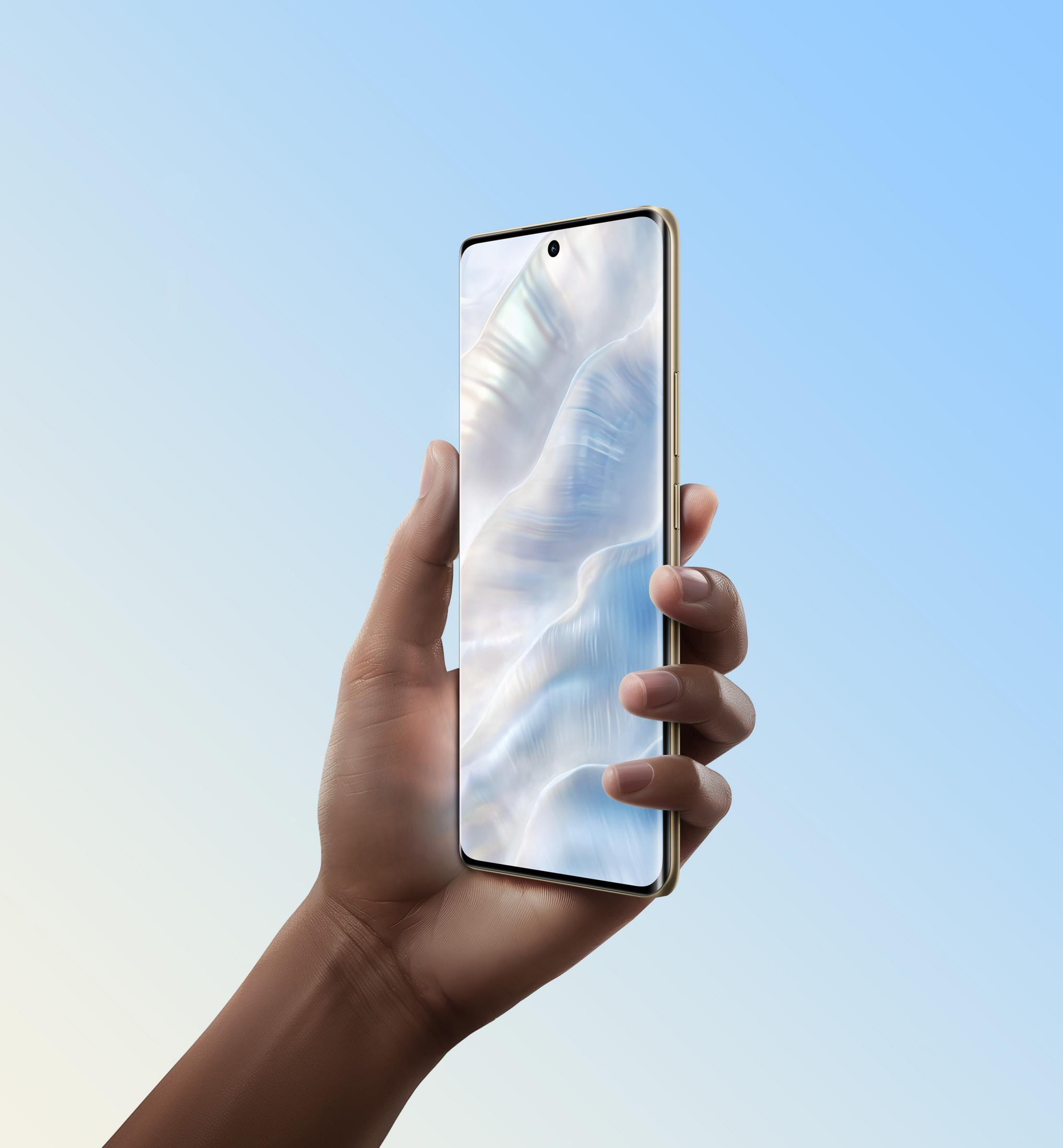 Dłoń trzyma smartfon ze złotą ramką na tle niebieskiego nieba.