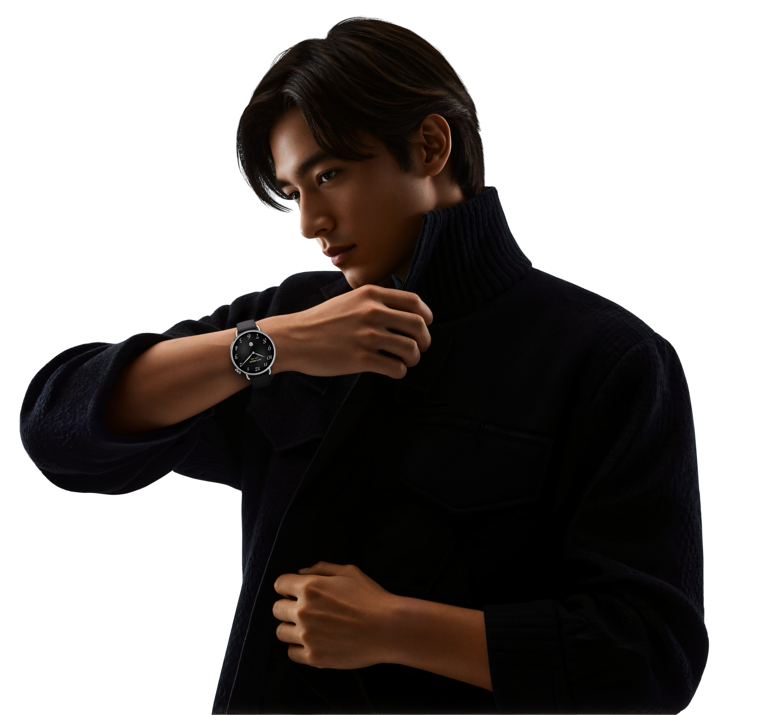 A man with dark hair adjusts his black turtleneck sweater.