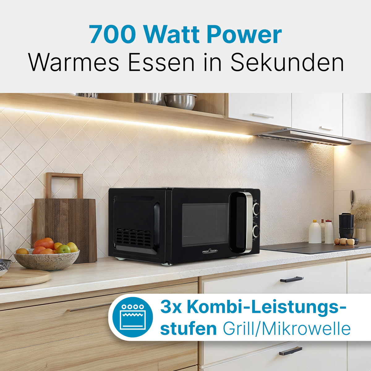Schwarze Mikrowelle auf einer Küchentheke mit Obstschale und Schränken.