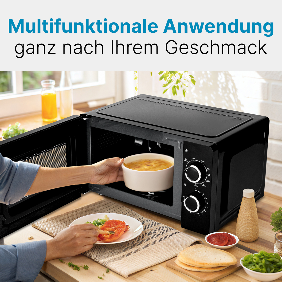 Eine Hand legt eine Schüssel mit Essen in eine schwarze Mikrowelle.