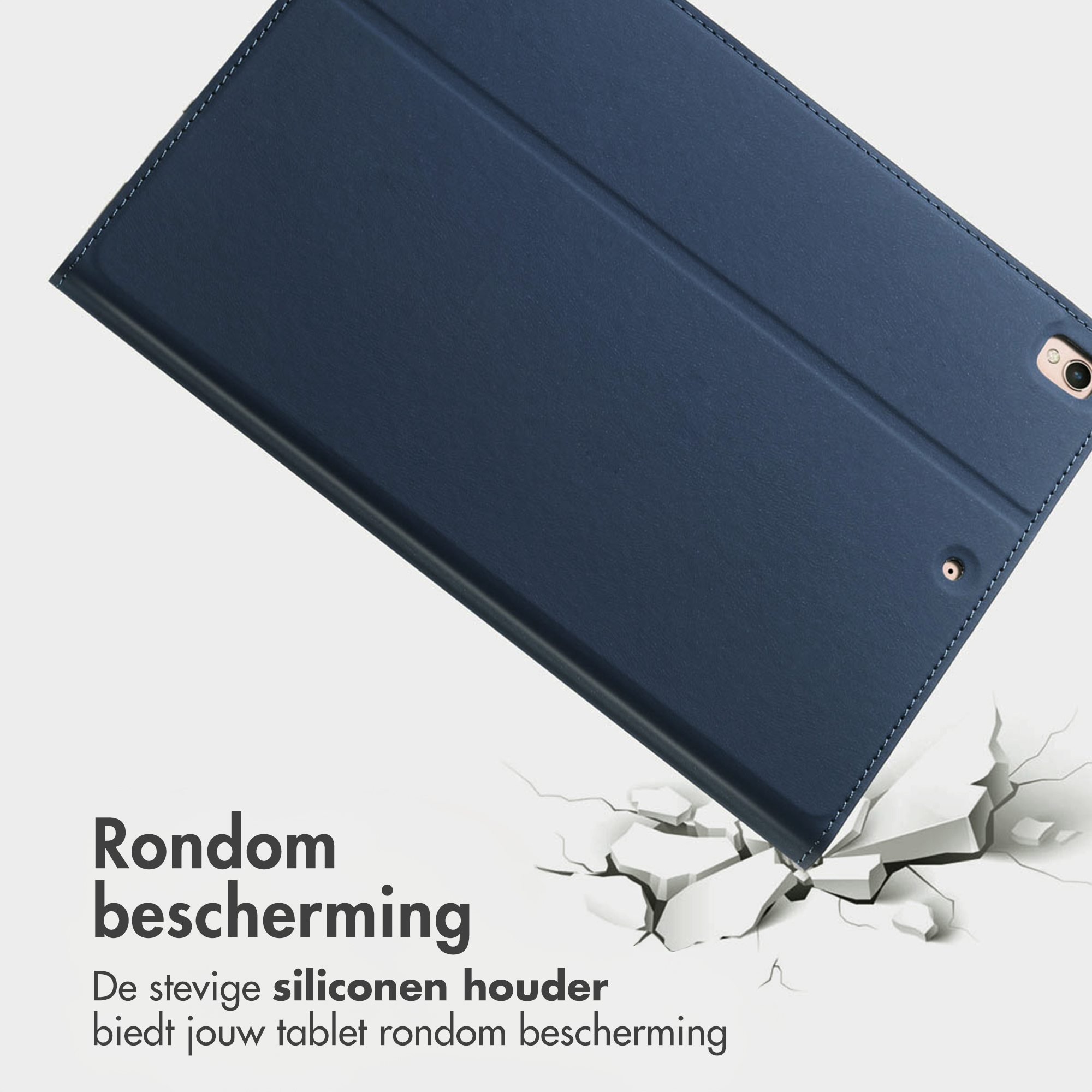 Donkerblauwe tablethoes met stiksels, rustend op gebarsten grond.