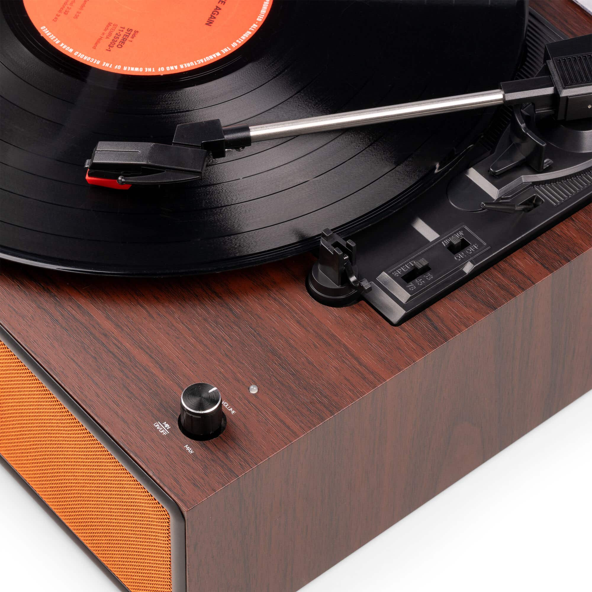 Primer plano de un tocadiscos con caja de madera marrón, disco de vinilo negro y brazo.