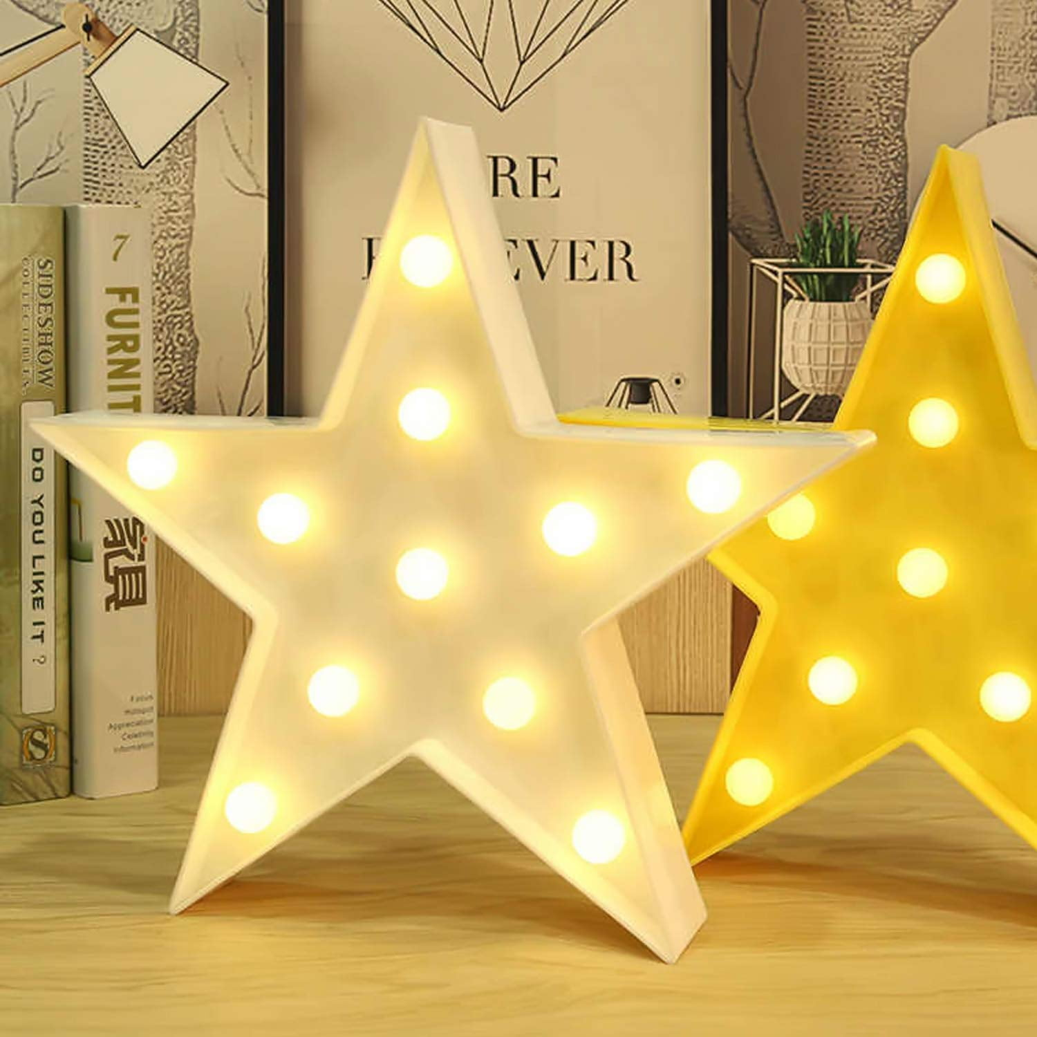 Zwei Sternlampen, eine weiße und eine gelbe, leuchten auf einem Holzschreibtisch.