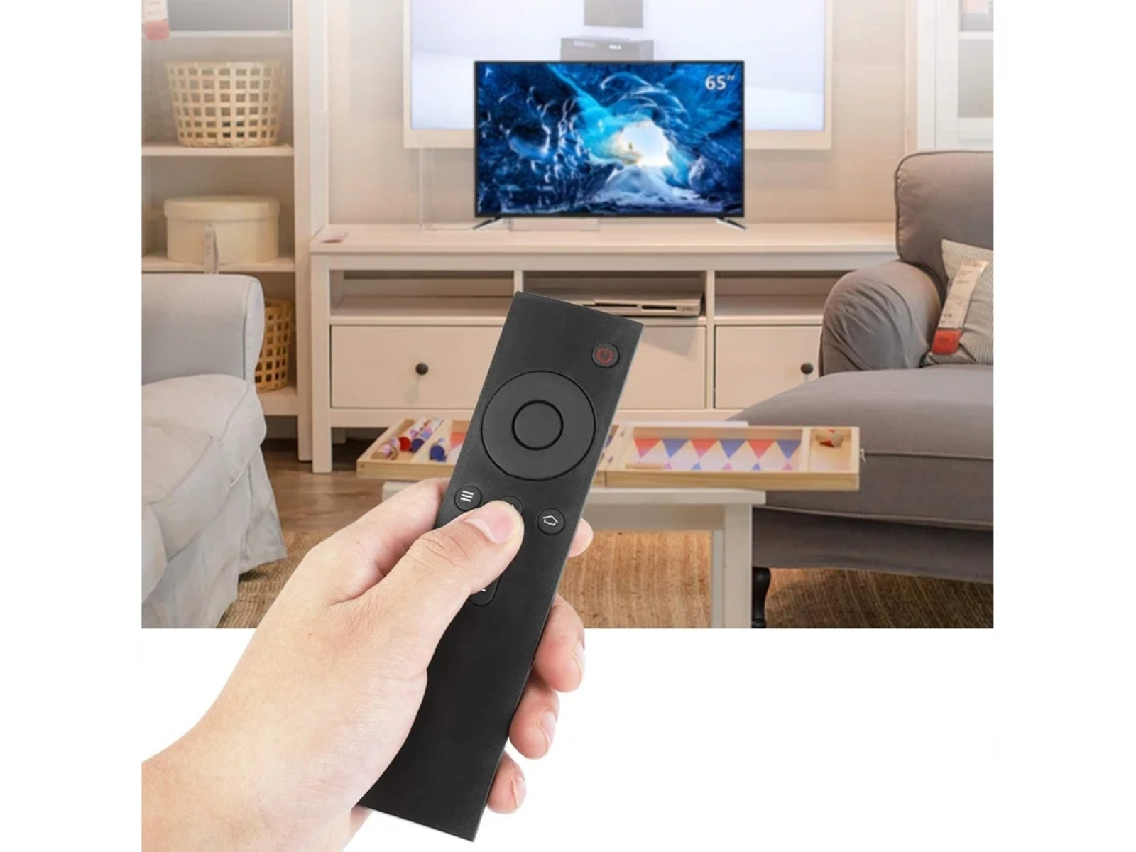 Eine Hand hält eine schwarze Fernbedienung vor einem Fernseher mit einem Eisbild.