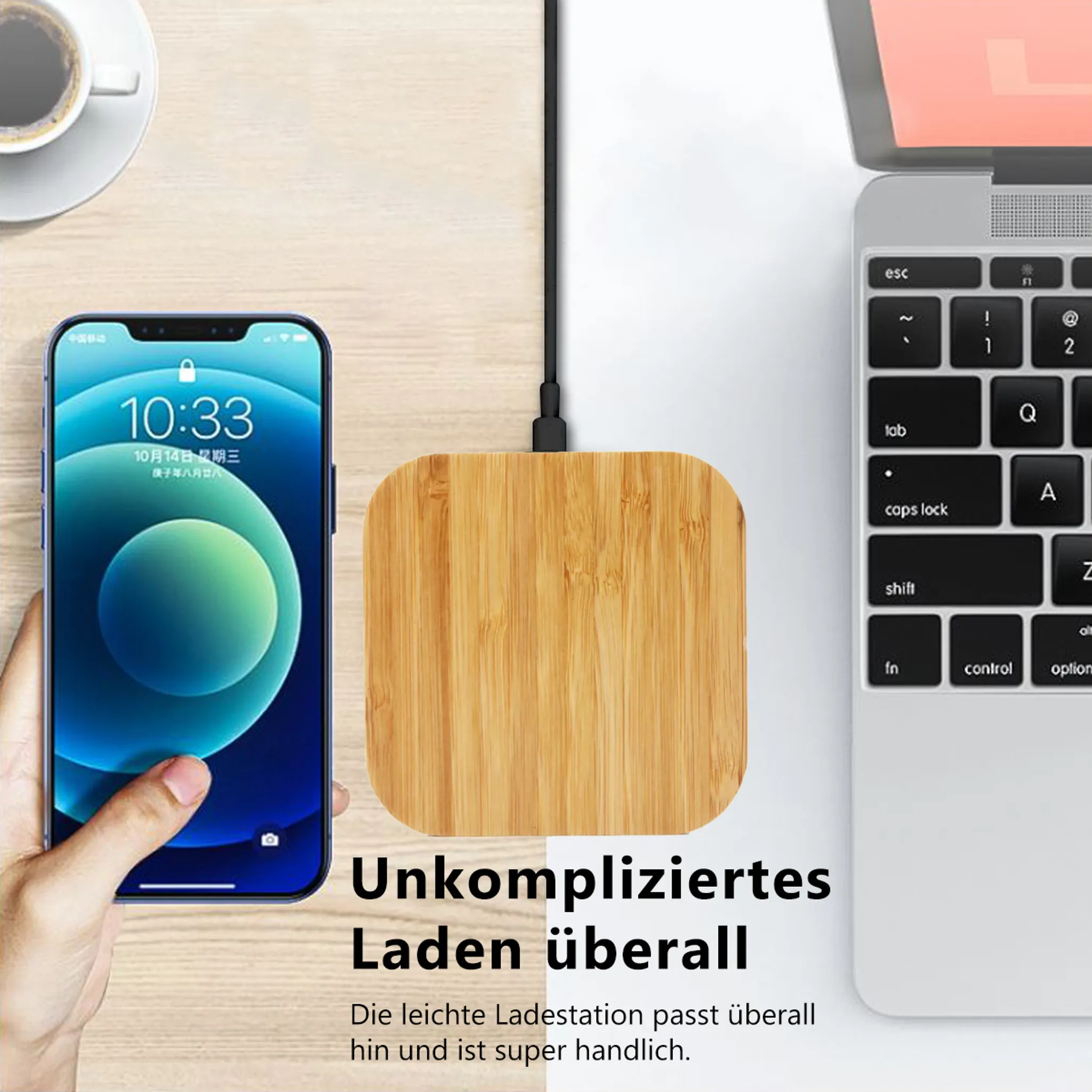 Holz-Ladepad mit Smartphone und Laptop daneben. Lädt bequem.