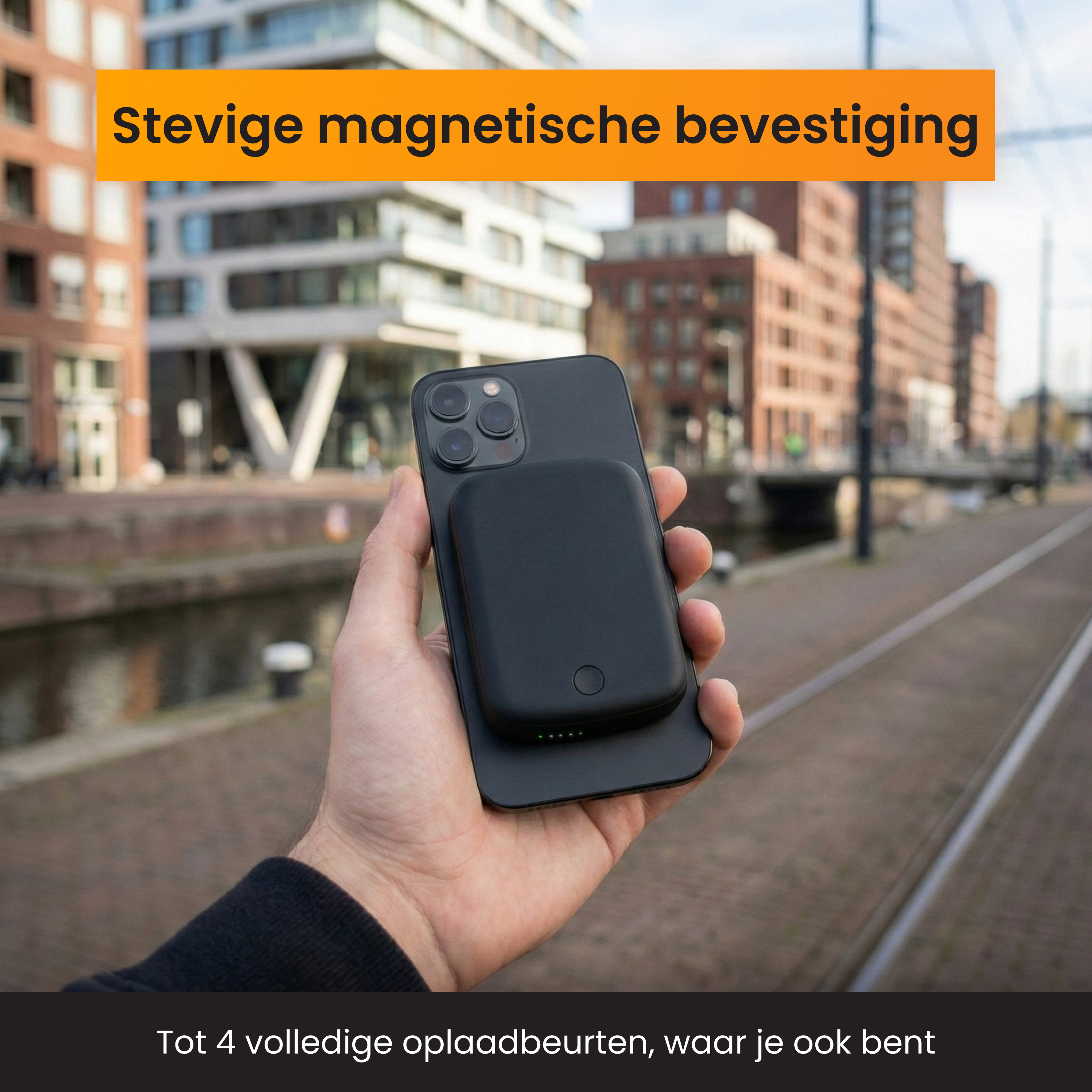 Un iPhone noir avec batterie magnétique, tenu en main devant des villes.