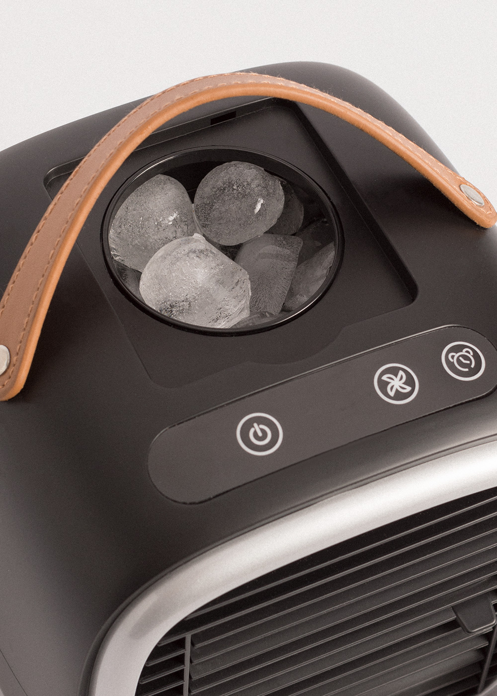 Máquina de hielo negra con asa de cuero y cubitos de hielo encima.