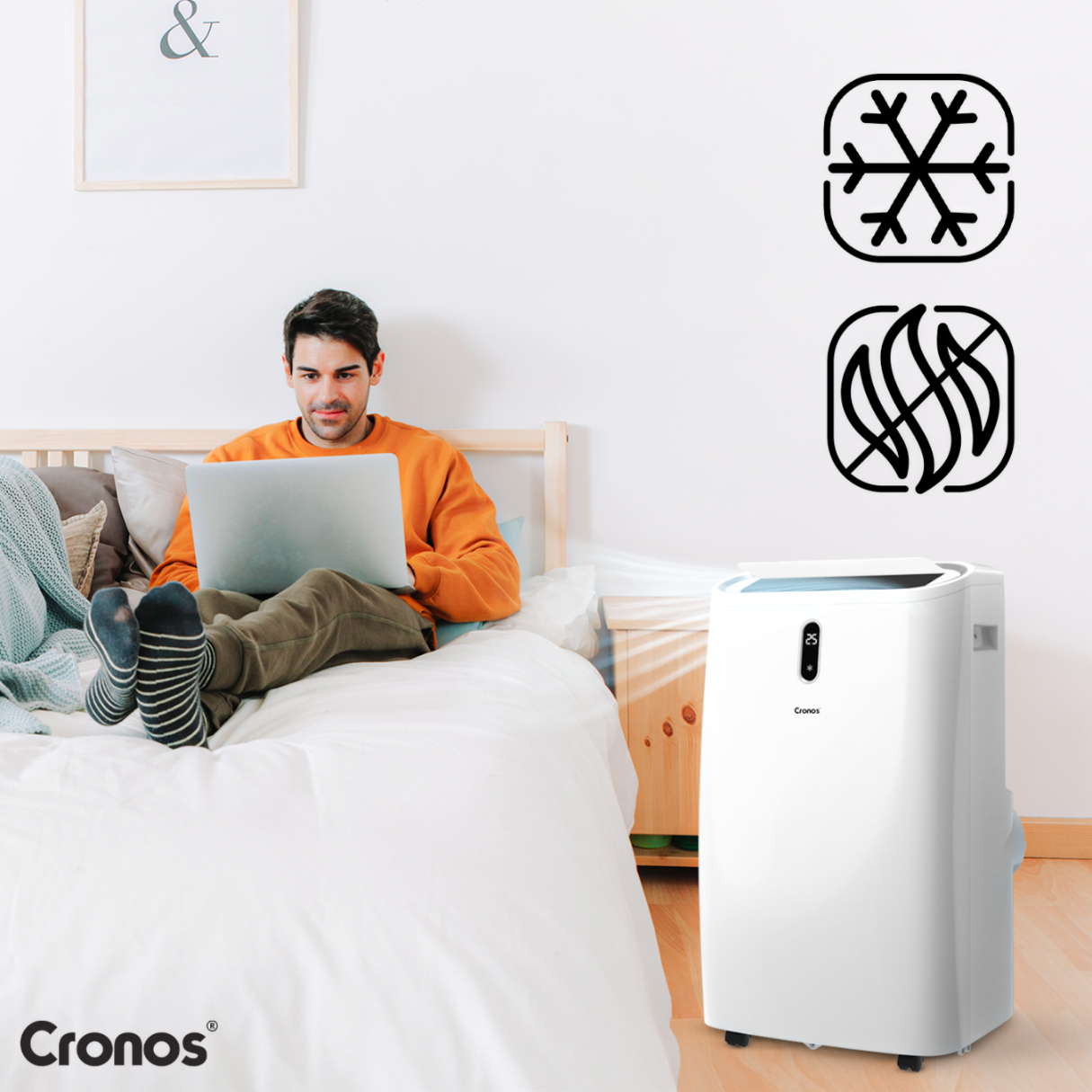 Mężczyzna na łóżku z laptopem obok białego klimatyzatora z symbolami zimna i ciepła.
