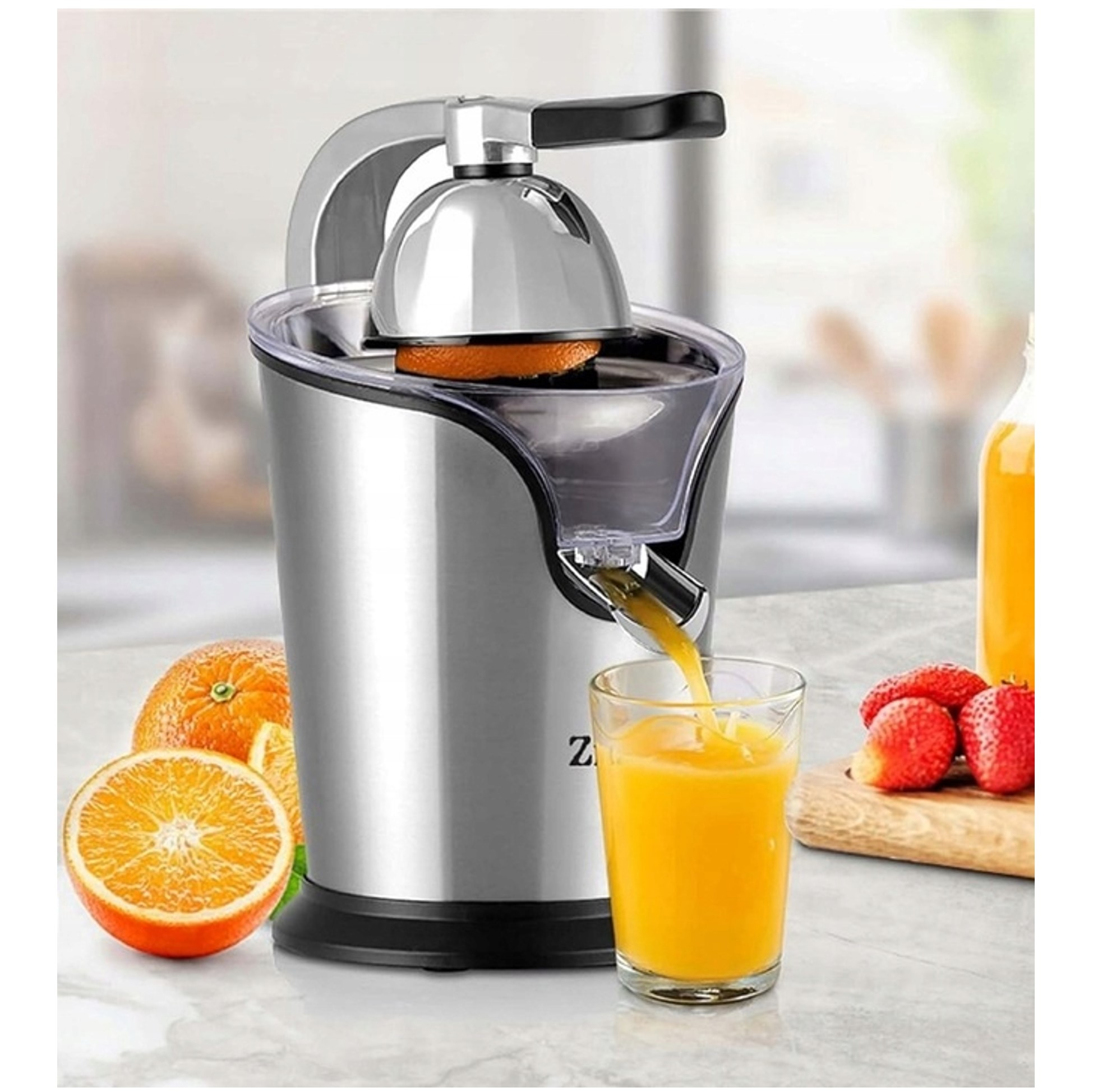 Sokowirówka wyciska sok pomarańczowy do szklanki, obok pomarańcze i truskawki.