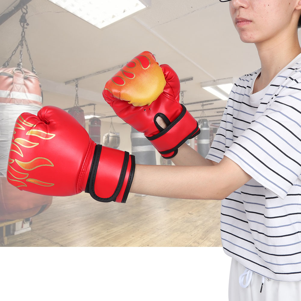 Rote Boxhandschuhe mit Flammenmuster in einem Fitnessstudio mit Sandsäcken.