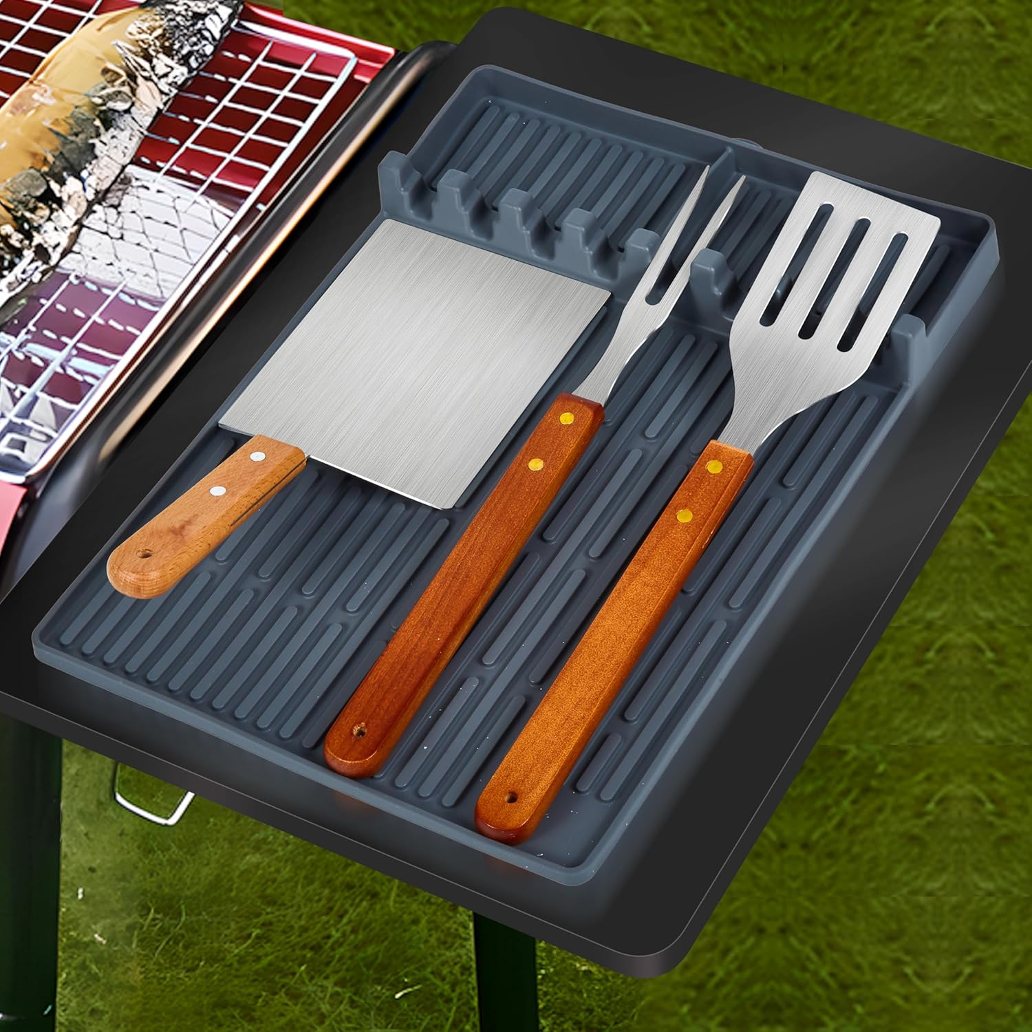 Grillwerkzeuge mit Holzgriffen in einem grauen Organizer auf einem Tisch