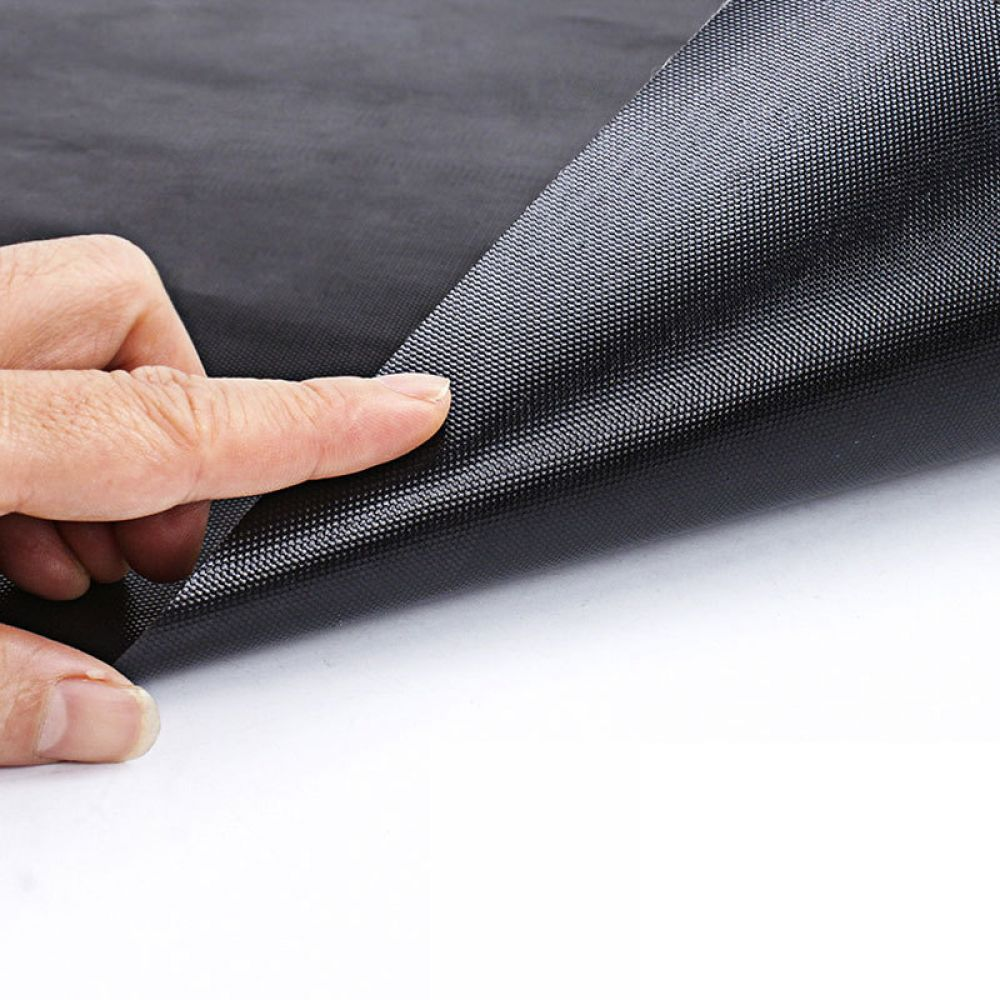Finger berührt eine schwarze, texturierte Oberfläche eines flexiblen Materials.
