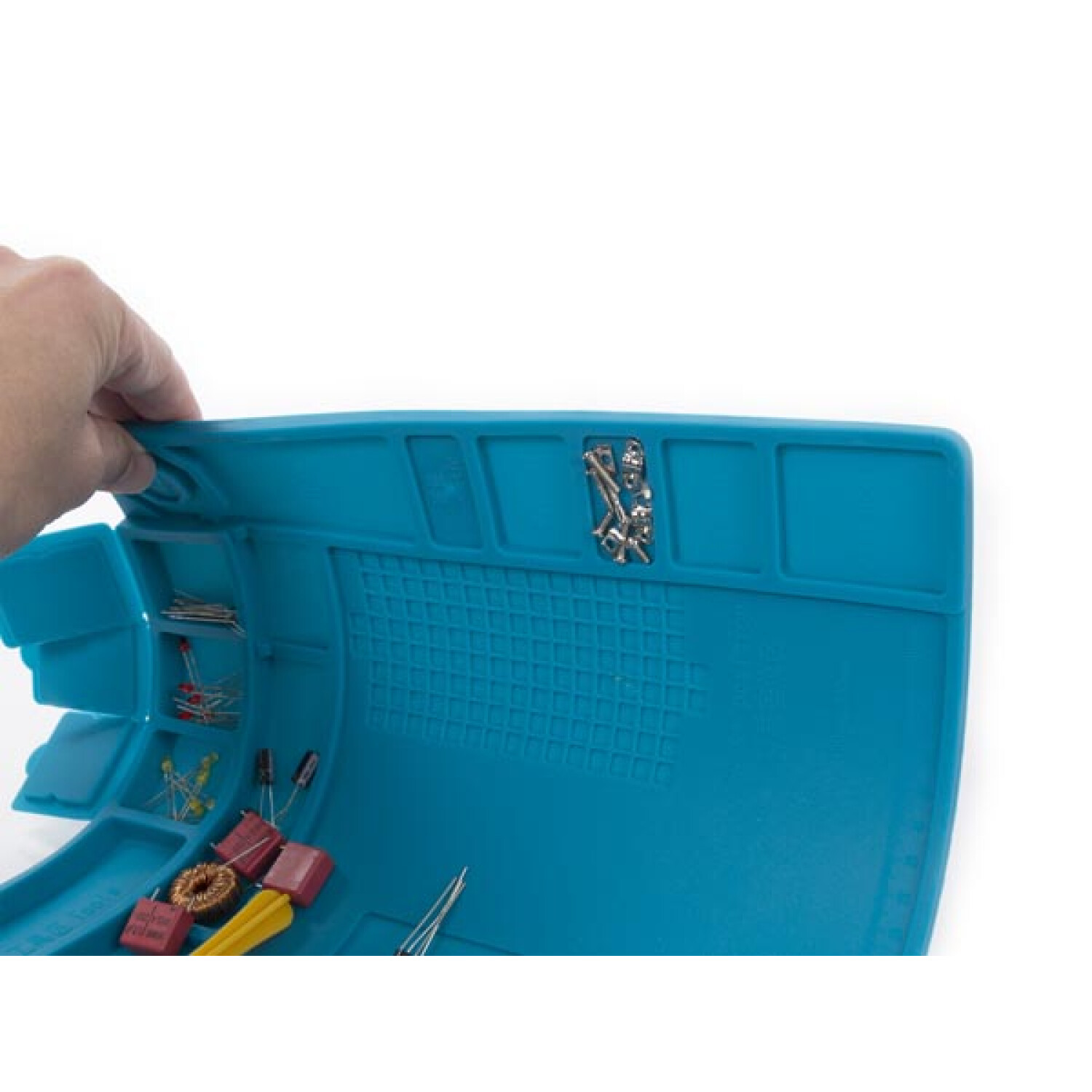 Una mano solleva un tappetino blu con componenti elettronici.