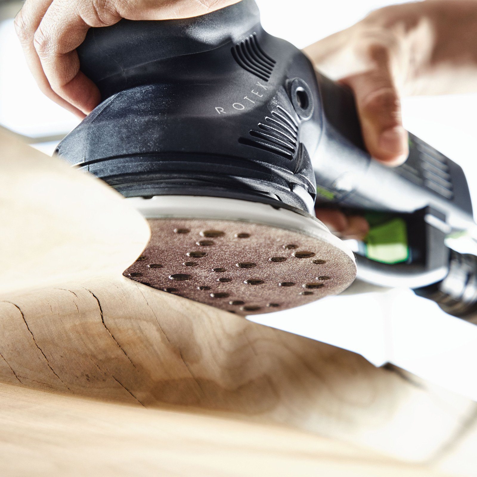 Una persona leviga legno con levigatrice elettrica. Vista ravvicinata.