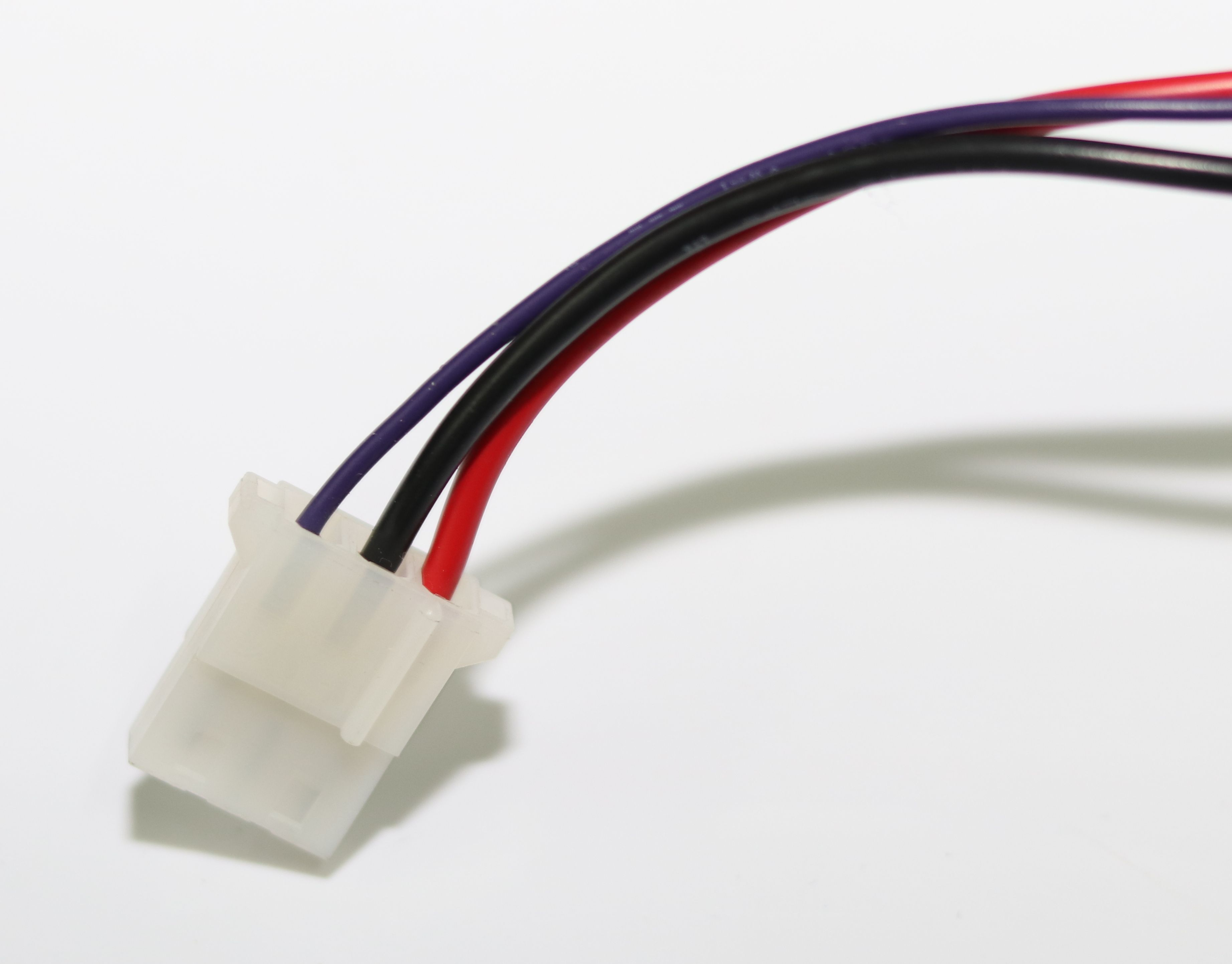 Ein weißer Stecker mit roten, schwarzen und violetten Kabeln.