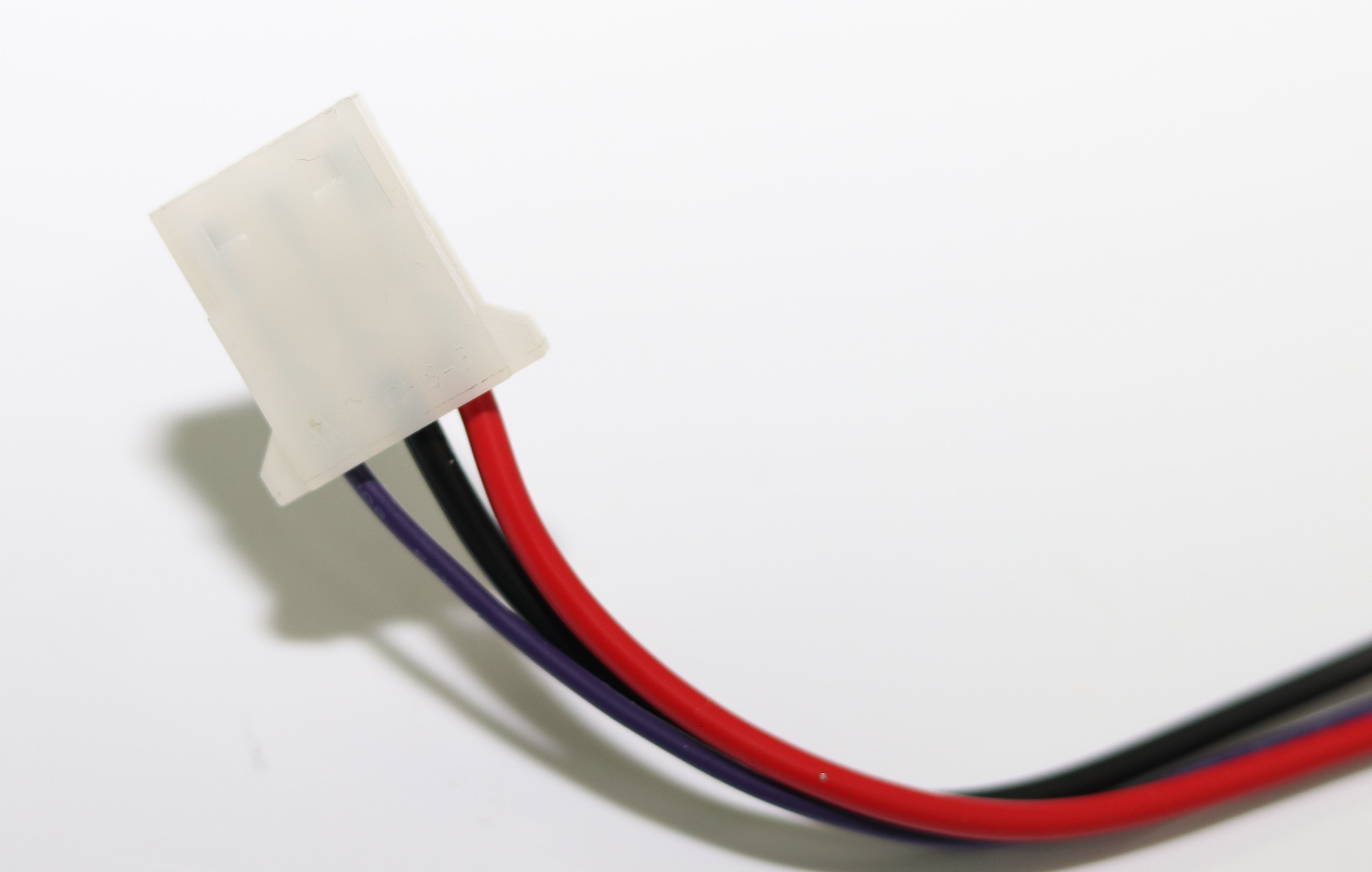 Ein weißer Stecker mit roten, schwarzen und violetten Kabeln.