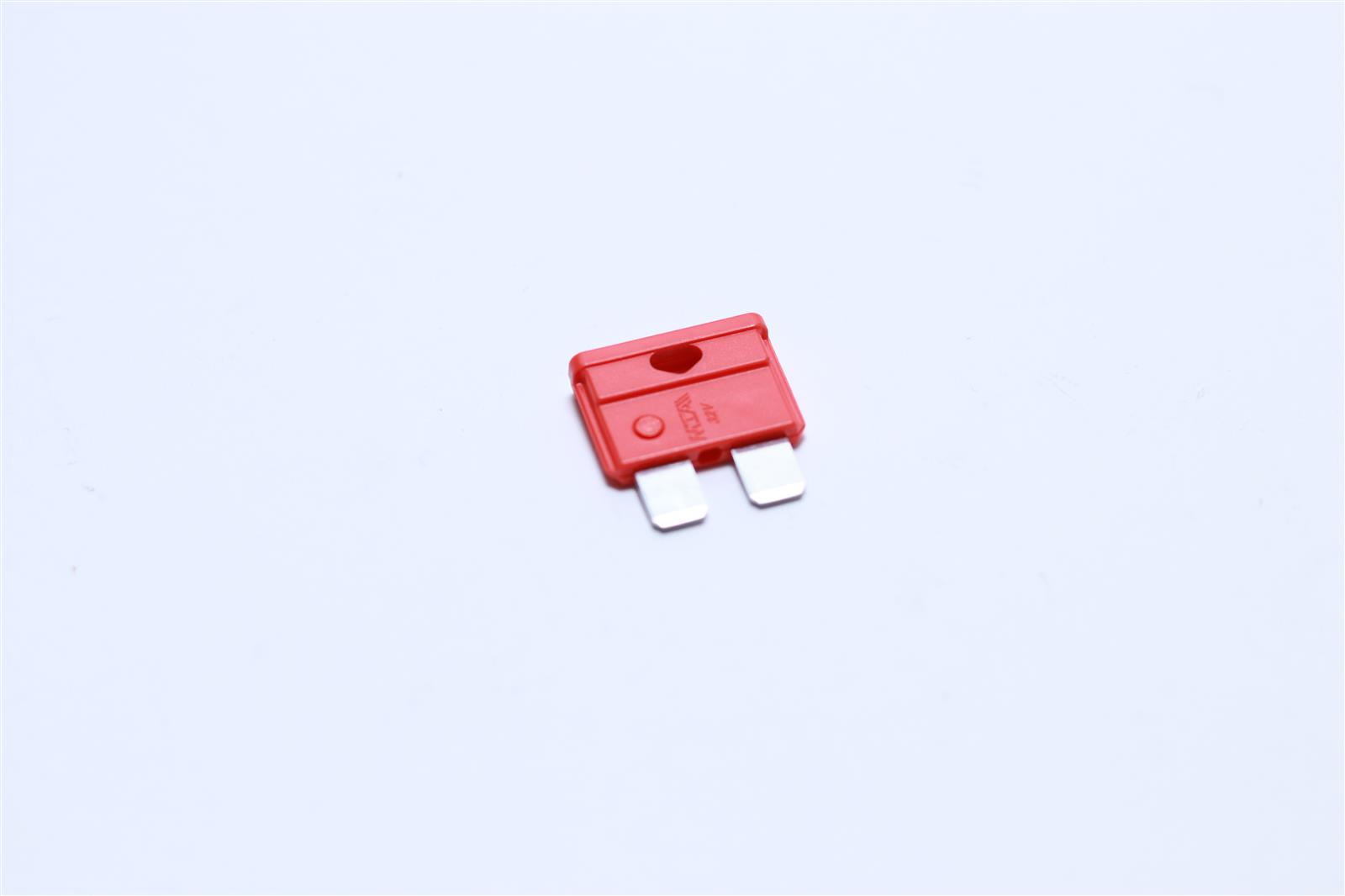 Ein roter Sicherungsstecker mit silbernen Metallkontakten auf weißem Hintergrund.
