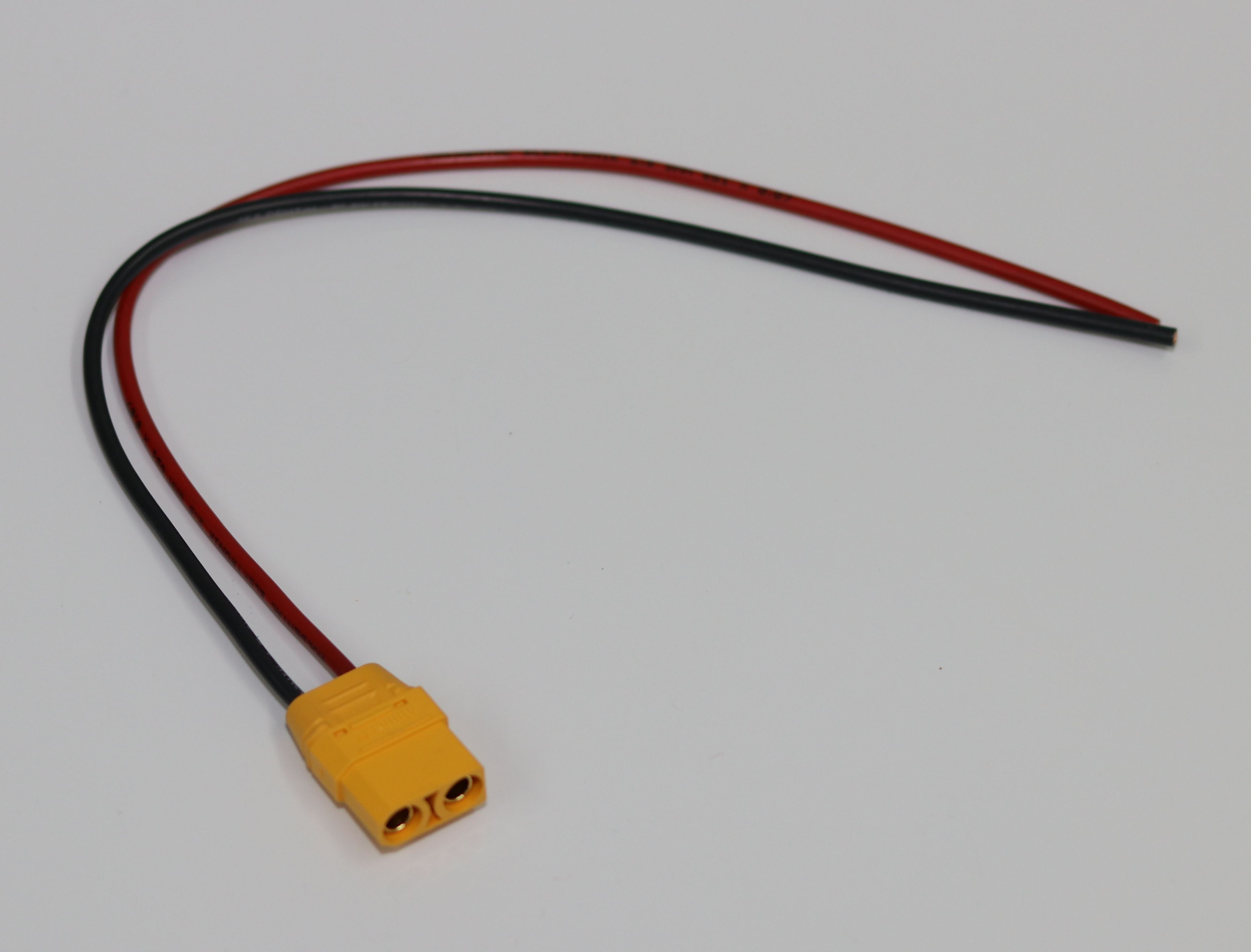 Ein gelber Stecker mit zwei roten und schwarzen Kabeln.