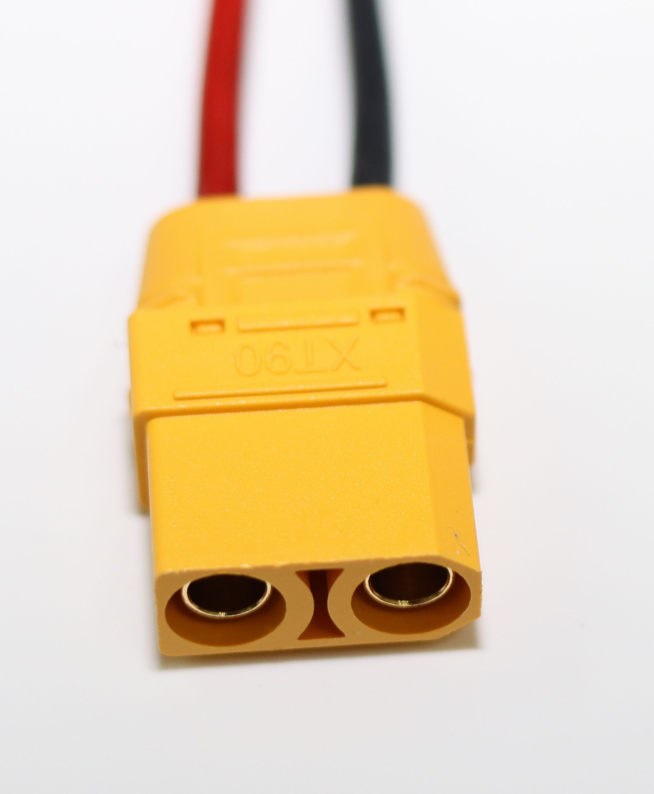Ein gelber XT90 Stecker mit roten und schwarzen Kabeln auf weißem Hintergrund.