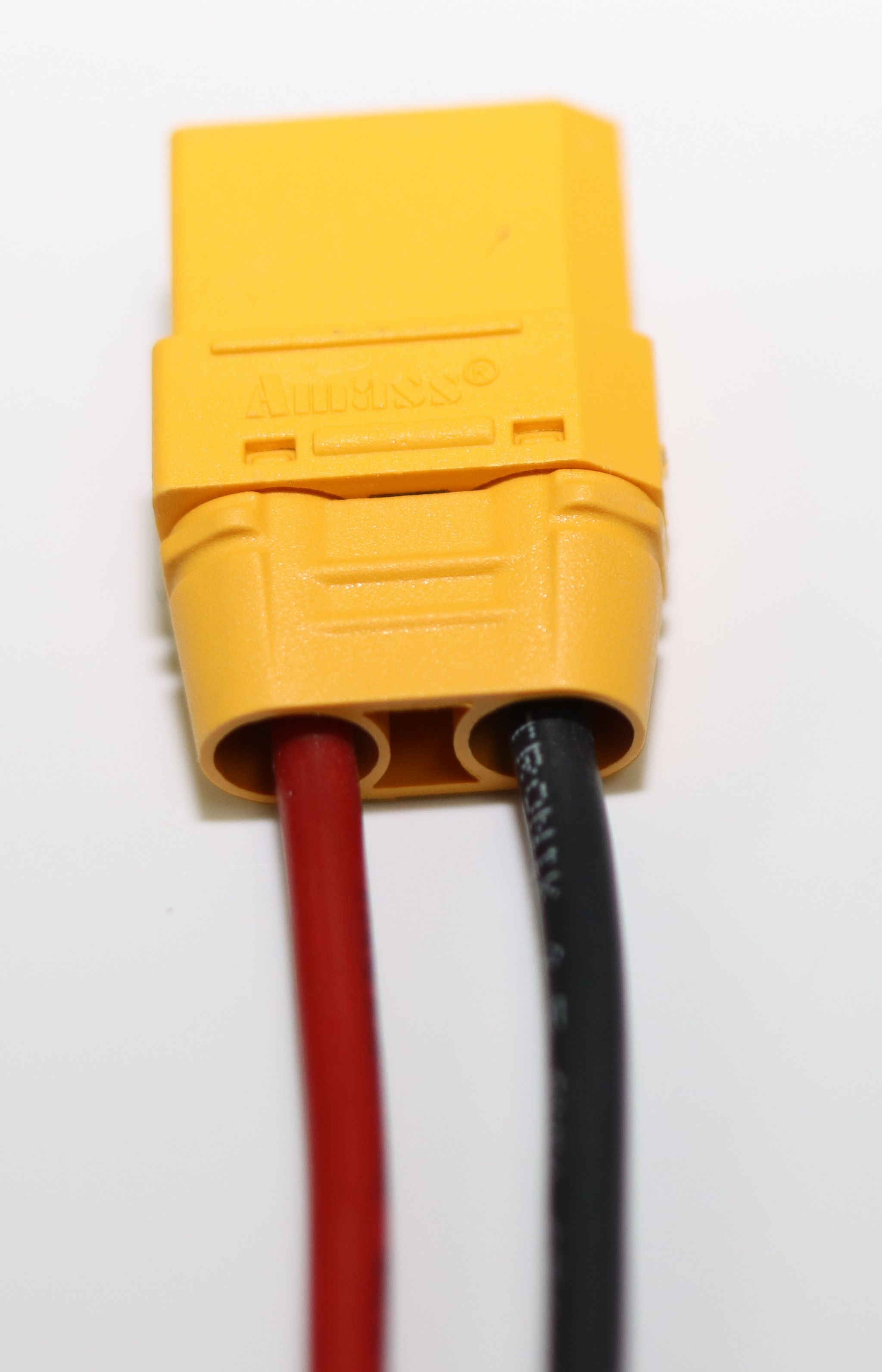 Gelber Stecker mit roten und schwarzen Kabeln.