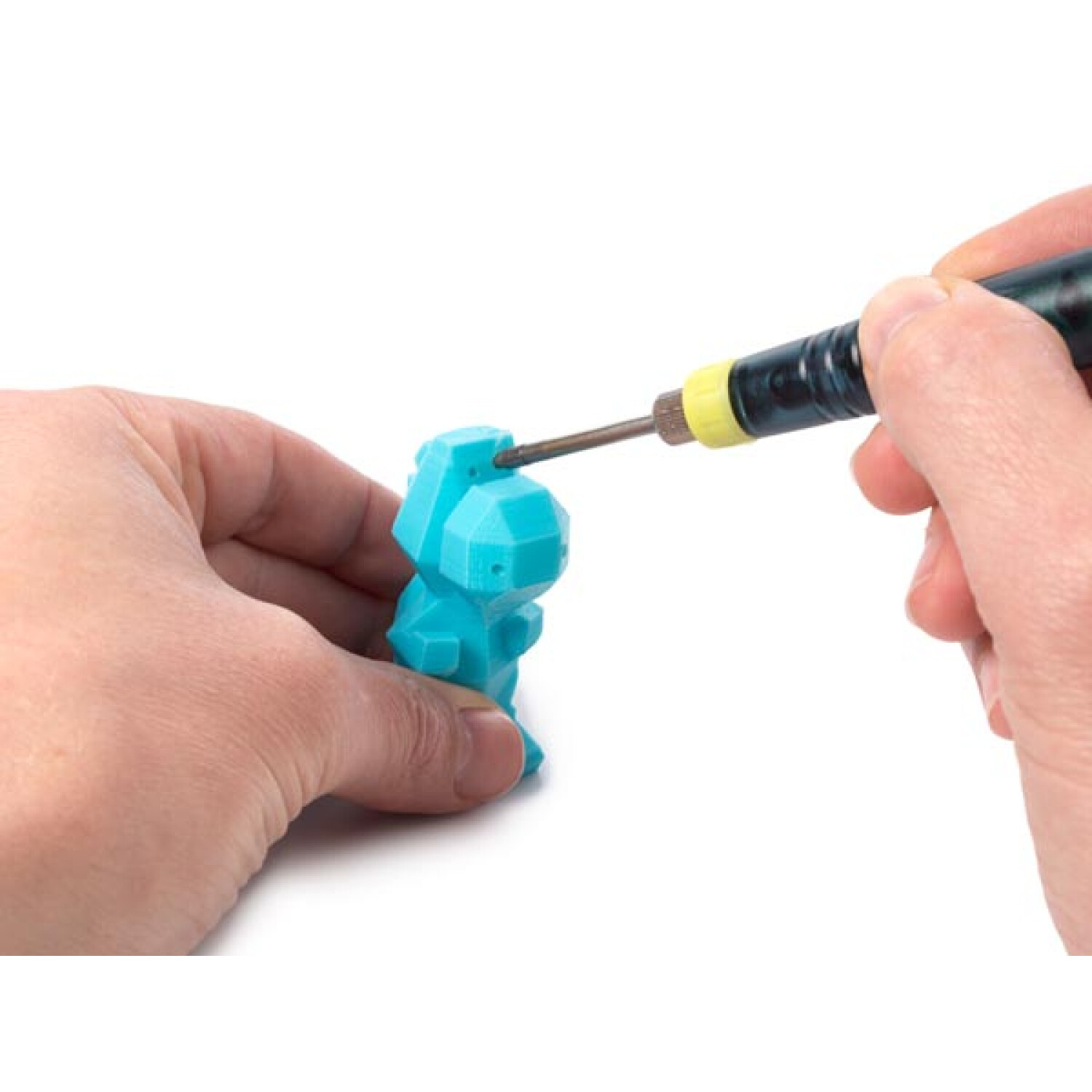 Una figura blu stampata in 3D viene lavorata da mani con uno strumento.
