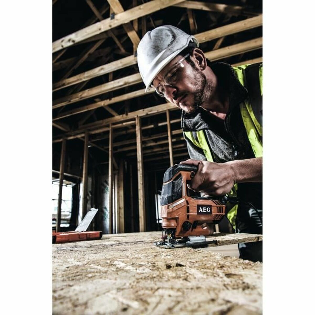 Un uomo con casco e gilet usa un seghetto alternativo sul legno.