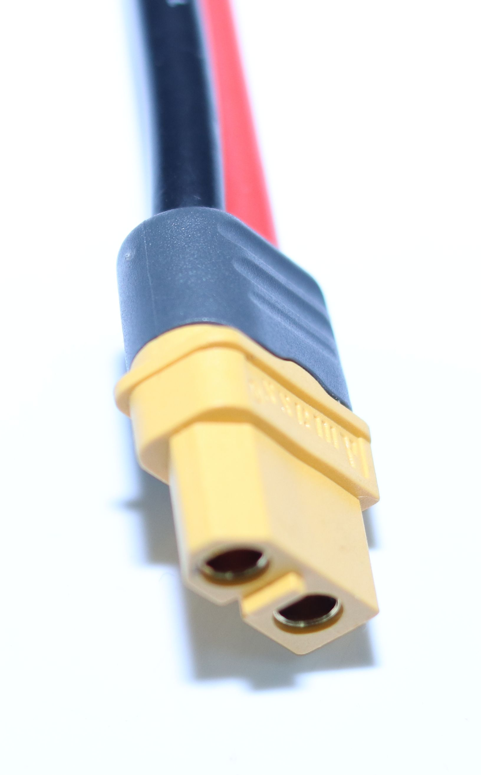 Ein gelber XT60-Stecker mit schwarzen und roten Kabeln.
