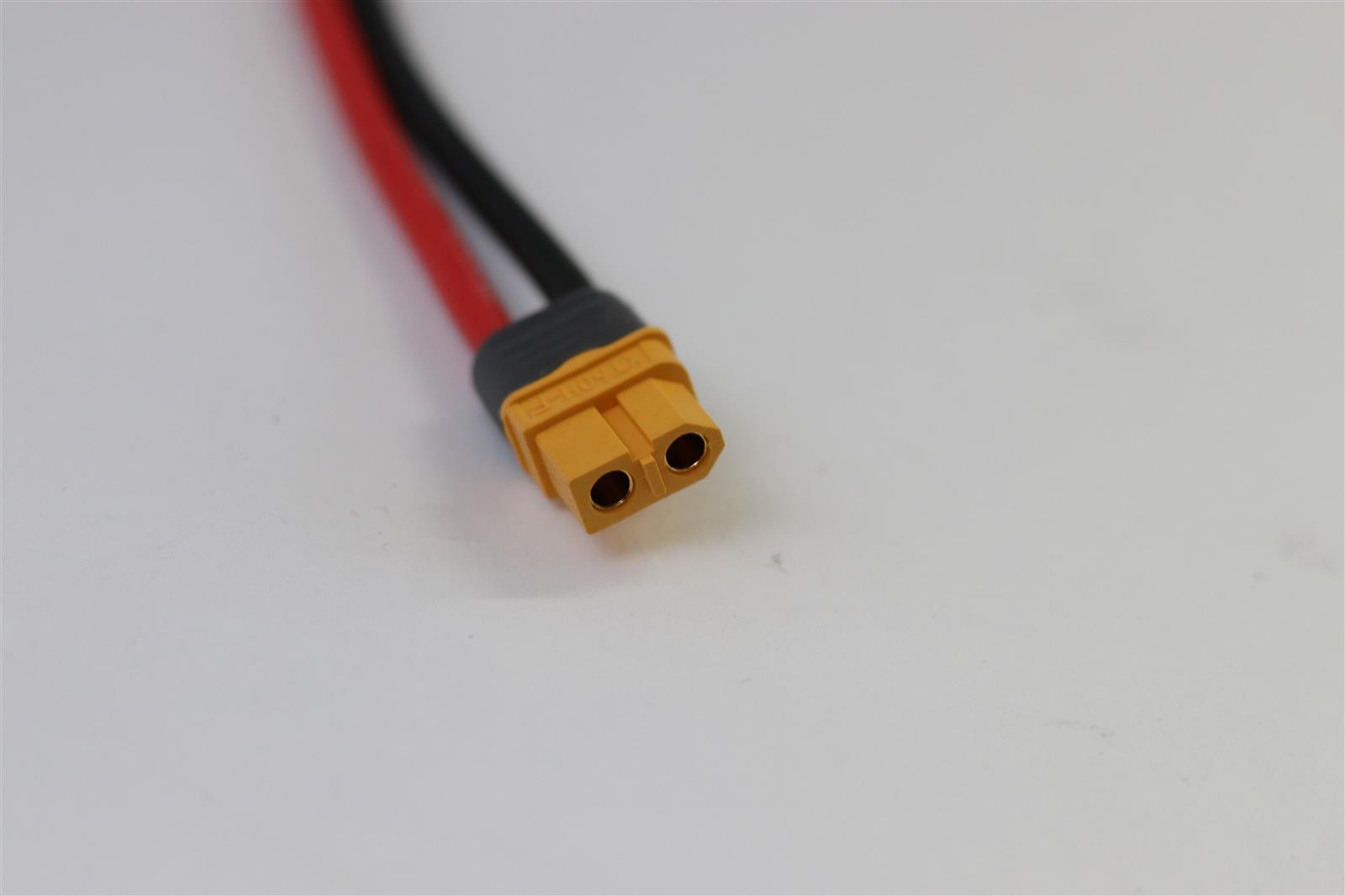 Ein gelber XT60-Stecker mit roten und schwarzen Kabeln auf weißem Hintergrund.