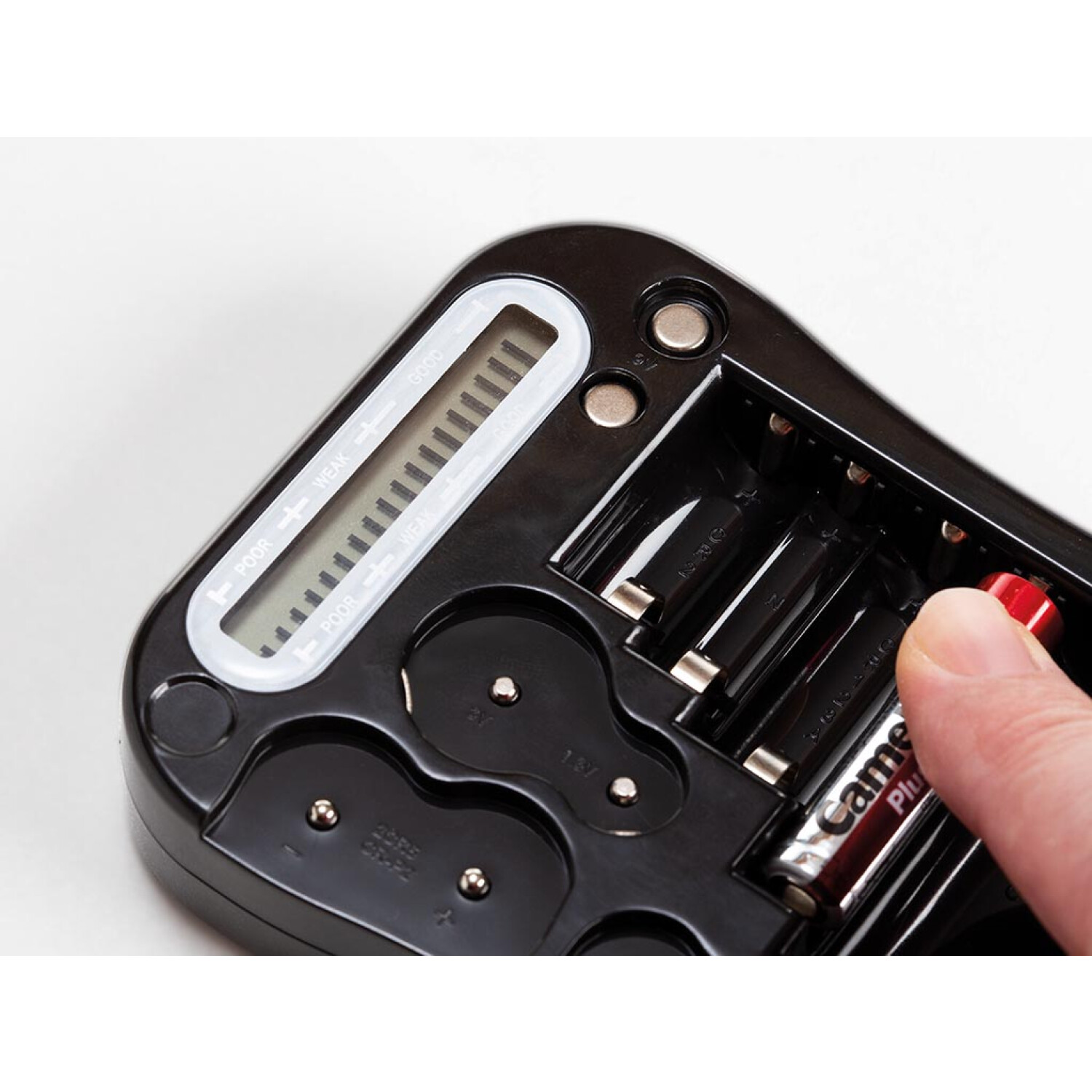 Ein Finger setzt eine rote Batterie in ein schwarzes Batterieladegerät ein.